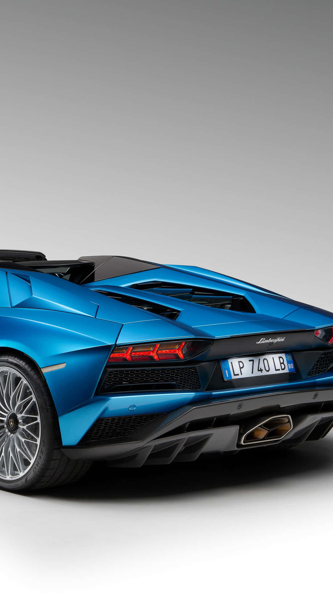 Blue Lamborghini iPhone 桌布 壁紙 — 一輛充滿活力的藍色藍寶堅尼跑車，帶有紅色尾燈和黑色飾件，從後方四分之三角度展示在純灰色背景前。