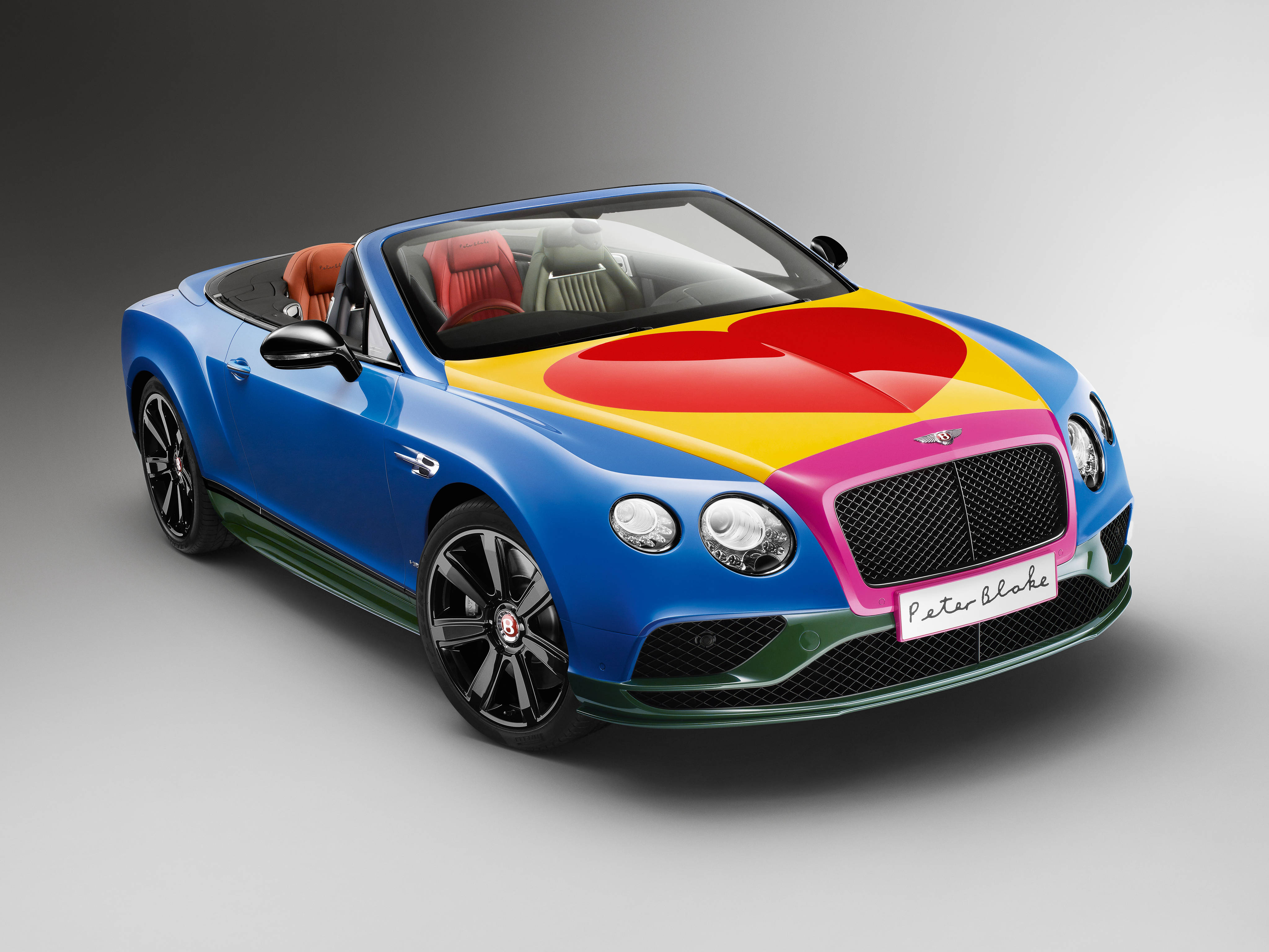 bentley HD 桌布 壁紙 — 一輛充滿活力的藍色賓利敞篷車，引擎蓋上有彩虹心形設計，紅色皮革座椅。