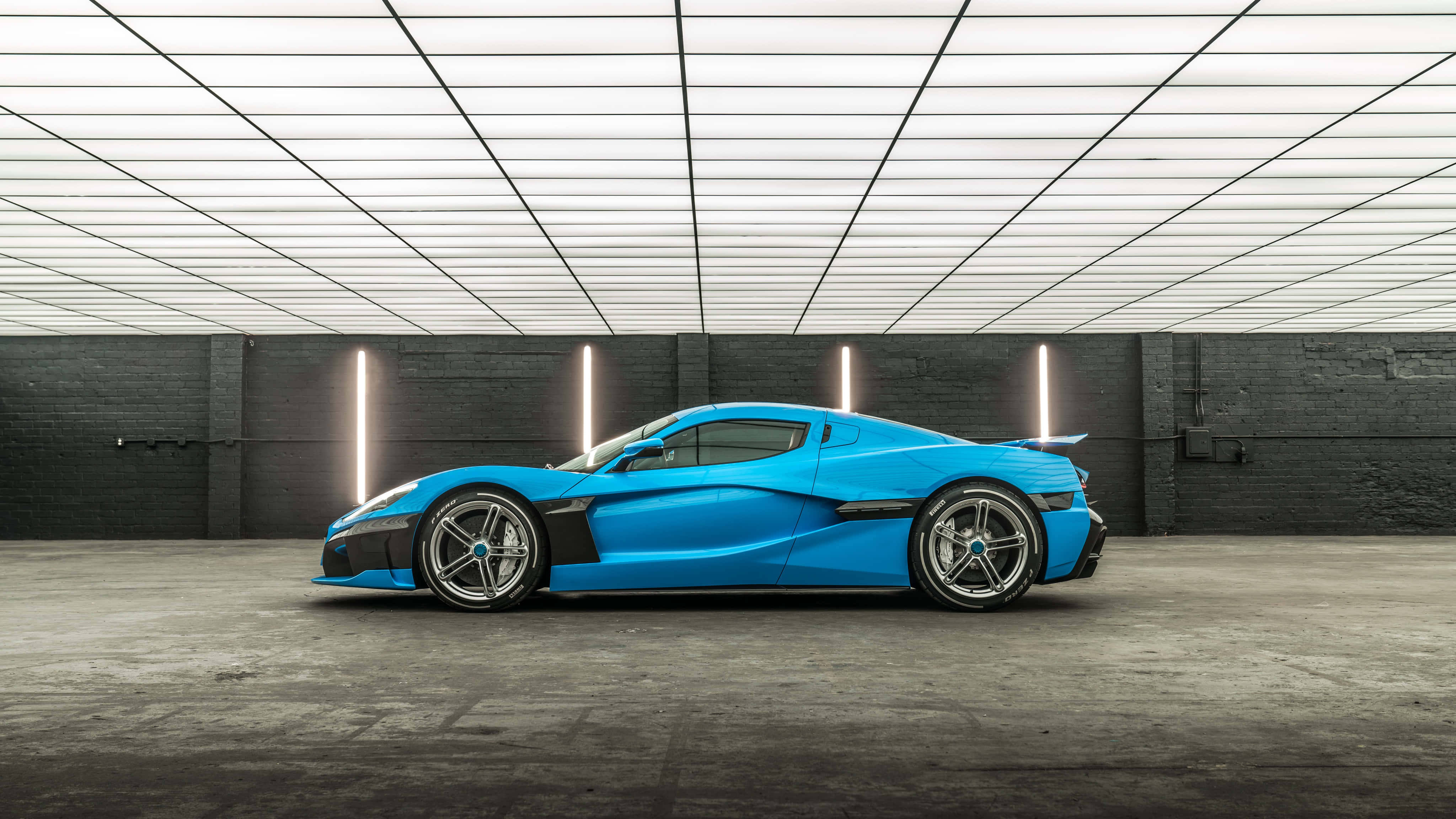 Rimac 桌布 壁紙 — 一輛充滿活力的藍色跑車在垂直霓虹燈下閃耀，位於一個帶有網格天花板的極簡工業車庫中。