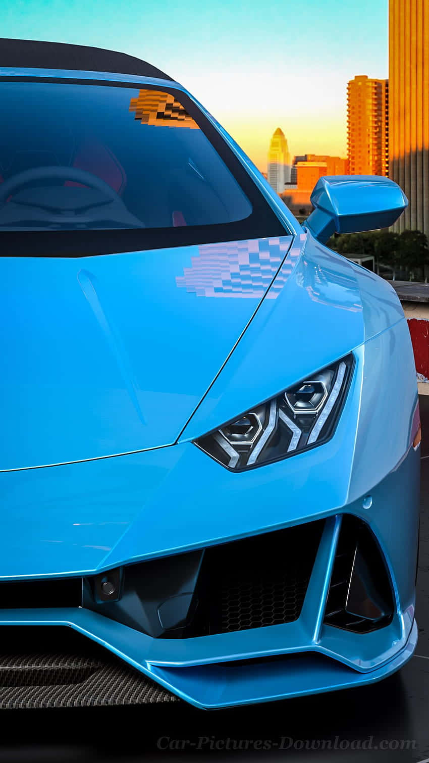 Pixel 3xl Lamborghini 桌布 壁紙 — 一輛充滿活力的藍色跑車在金色夕陽下閃閃發光，背景是城市天際線。