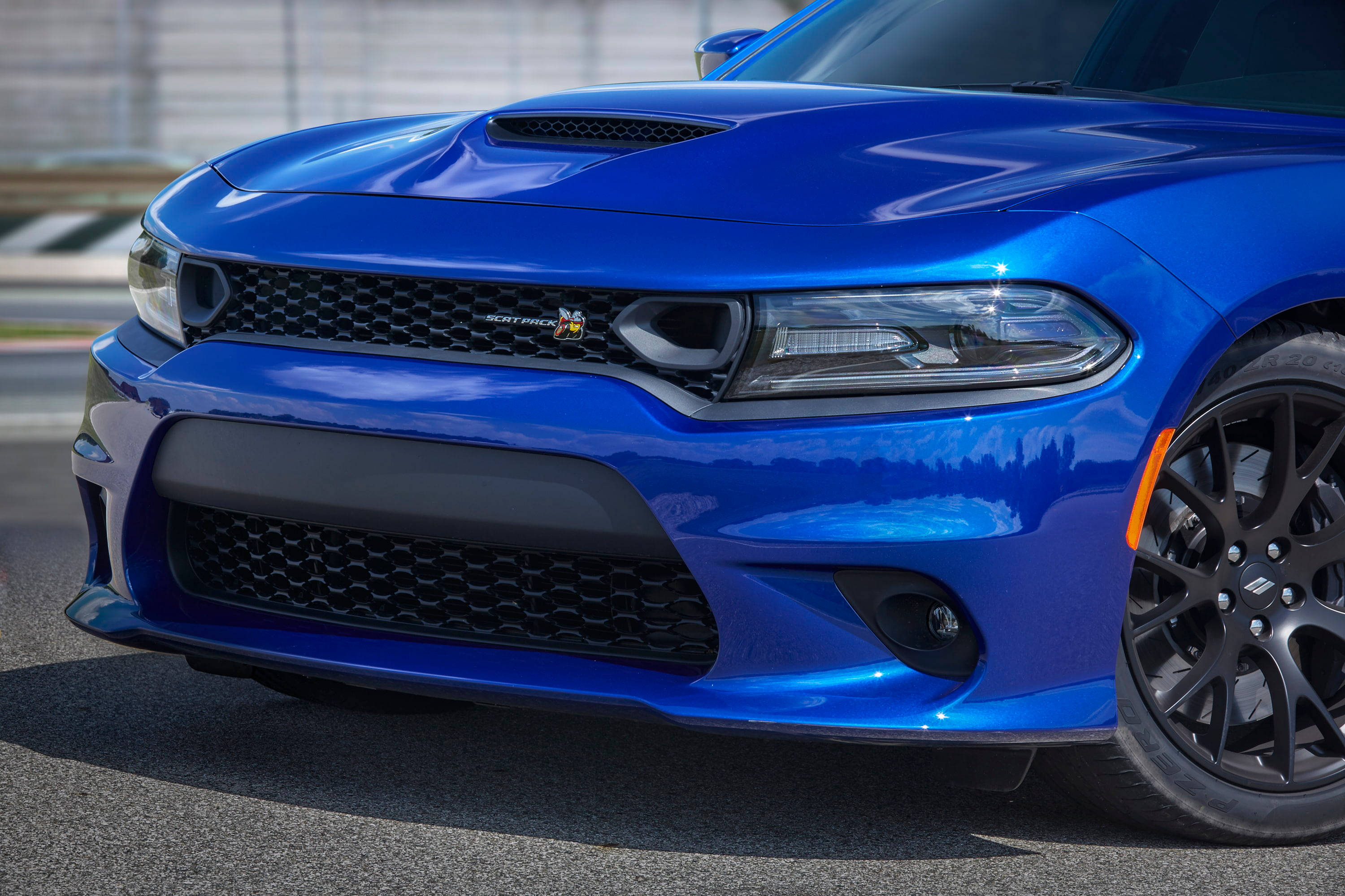 Mopar 桌布 壁紙 — 一輛充滿活力的藍色道奇挑戰者SRT Hellcat，帶有黑色飾邊和橙色點綴，停在陽光普照的瀝青路面上。