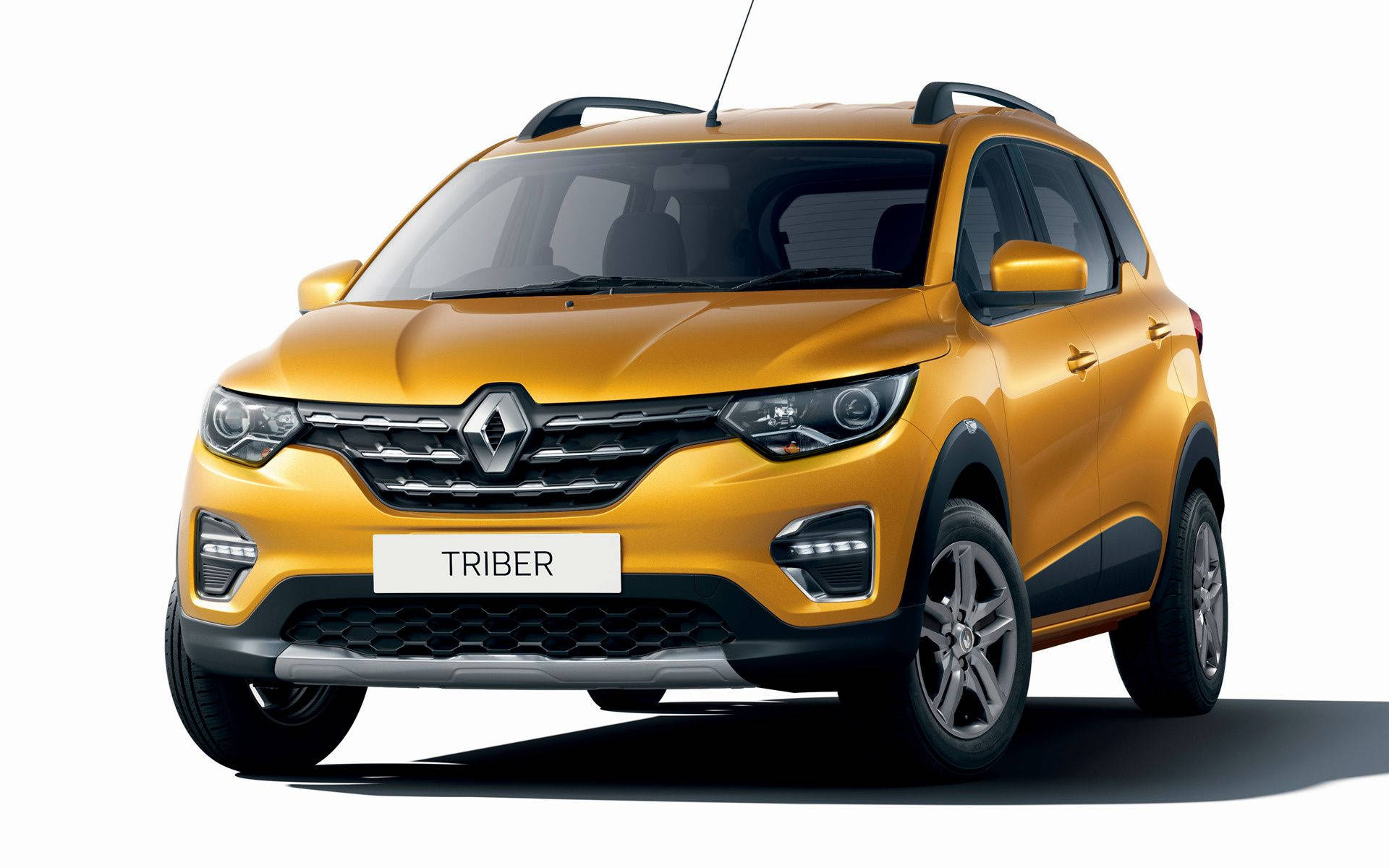 Renault 桌布 壁紙 — 一輛充滿活力的金色雷諾 Triber SUV，在工作室燈光下展示，線條簡潔，車頭燈現代化。