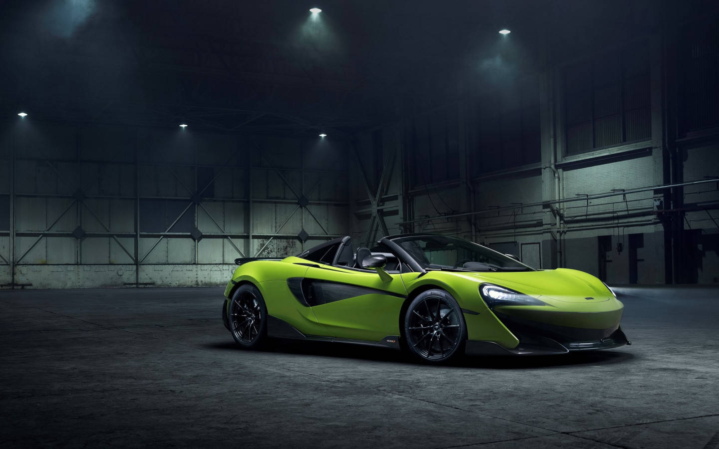 跑車 桌布 壁紙 — 一輛充滿活力的青檸綠色McLaren跑車在昏暗的工業倉庫中，於強烈聚光燈下閃閃發光。