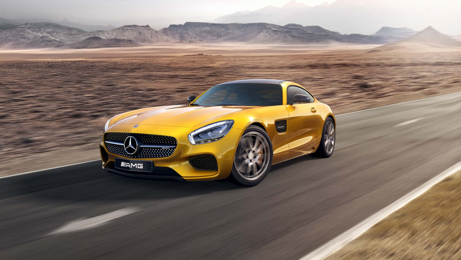 黃色 Mercedes-AMG GT 在沙漠公路上奔馳，背景有山脈。