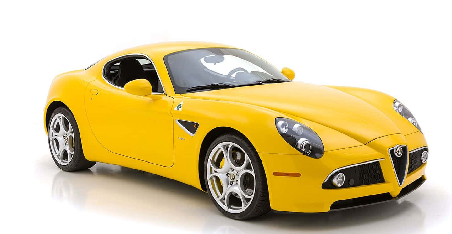 Alfa Romeo 8c Competizione 桌布 壁紙 — 一輛充滿活力的黃色Alfa Romeo跑車在攝影棚燈光下，於純白背景中閃耀光芒。