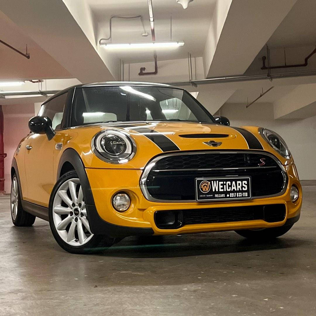 Black And Yellow 桌布 壁紙 — 一輛充滿活力的黃色Mini Cooper S，帶有黑色賽車條紋，停在光線充足的地下停車場。