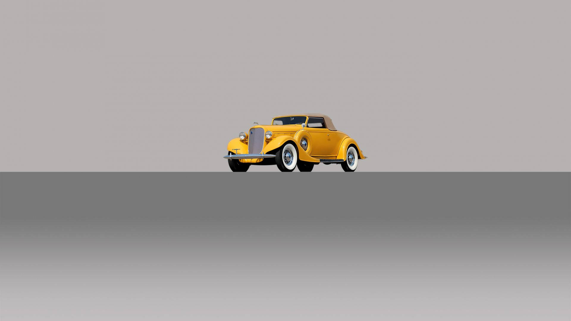 Vintage Minimalist 桌布 壁紙 — 一輛充滿活力的黃色經典敞篷車，配以棕褐色車頂，居中放置在簡約灰色漸變背景上。