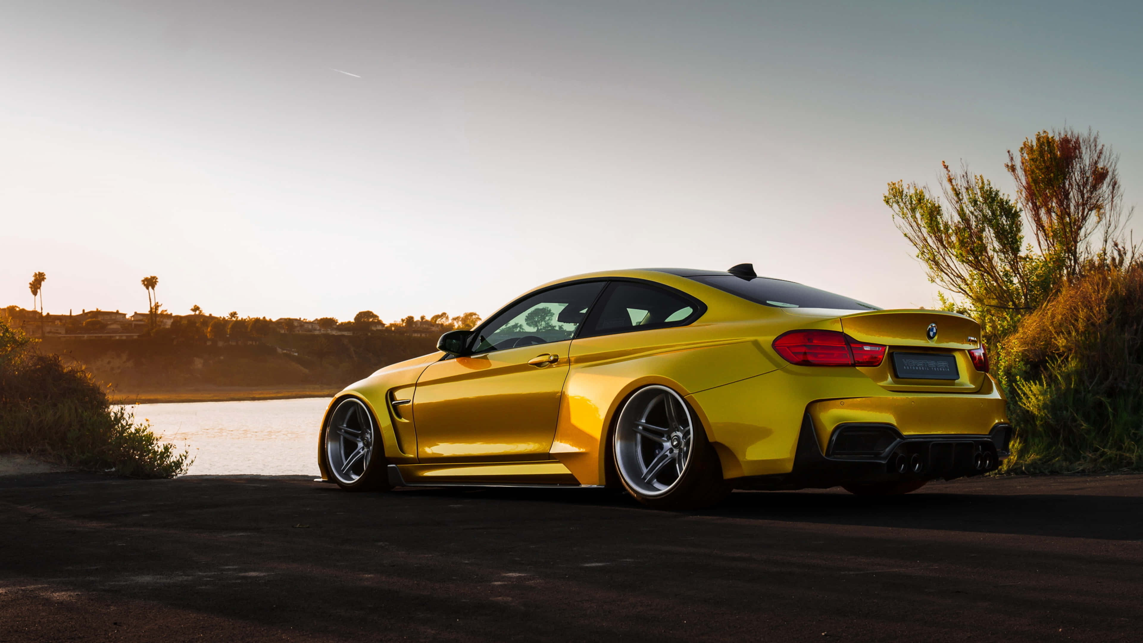 Gold Cars 桌布 壁紙 — 一輛充滿活力的黃色跑車停在平靜的湖邊，正值黃金時刻，溫暖的陽光凸顯其流暢的曲線。