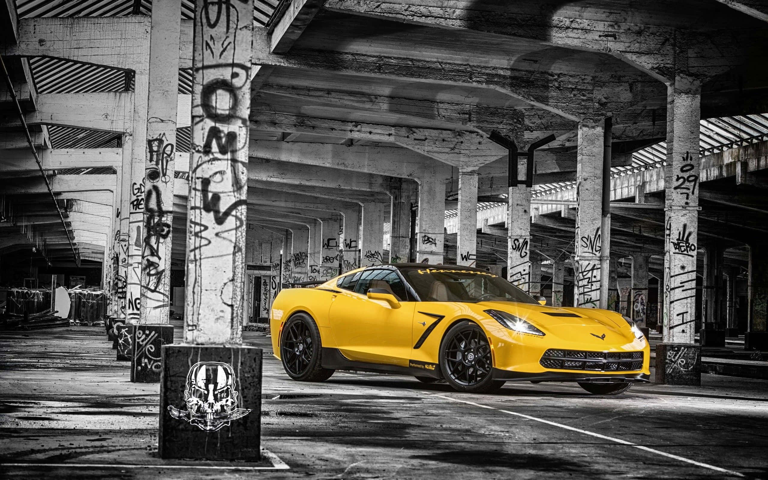 Yellow Car 桌布 壁紙 — 一輛充滿活力的黃色跑車在塗鴉覆蓋的廢棄混凝土結構內，在強烈燈光下閃閃發光。