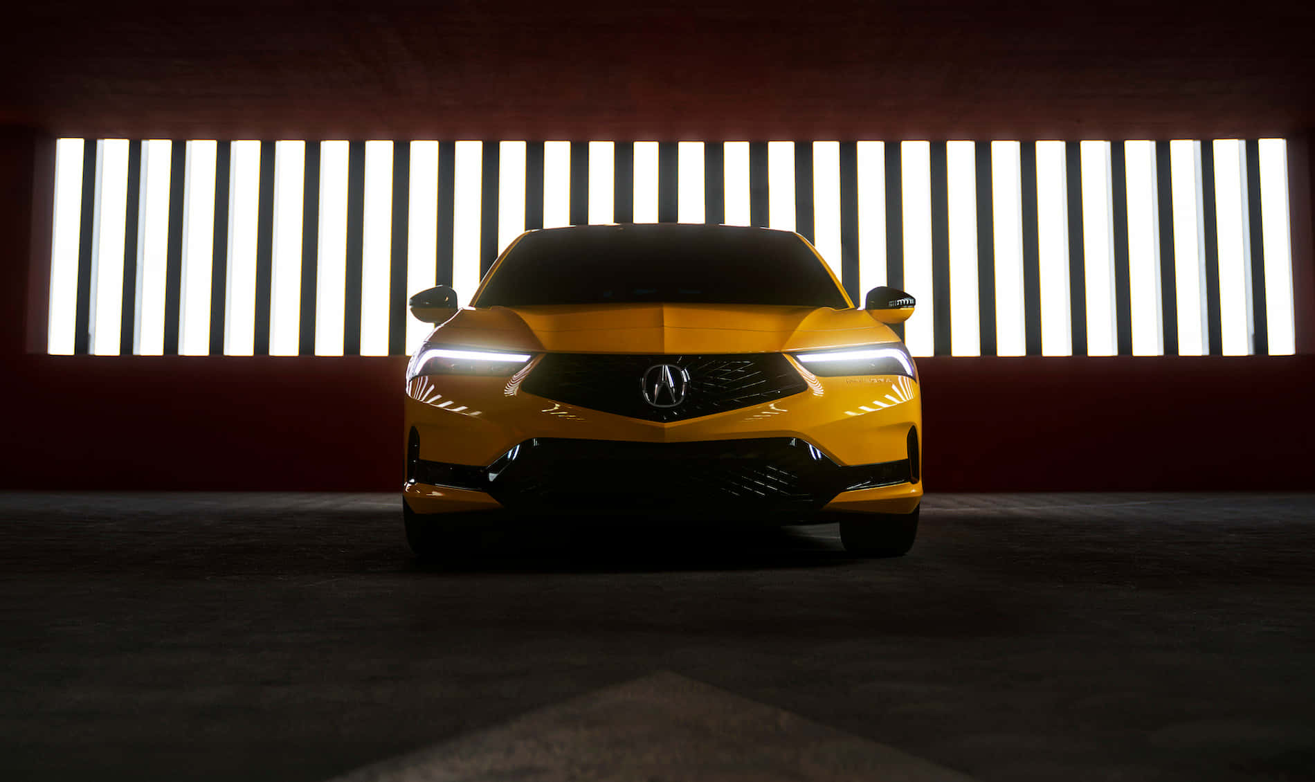 Acura Integra 桌布 壁紙 — 一輛充滿活力的黃色跑車在昏暗的紅牆車庫中，在銳利的垂直燈條下閃閃發光。