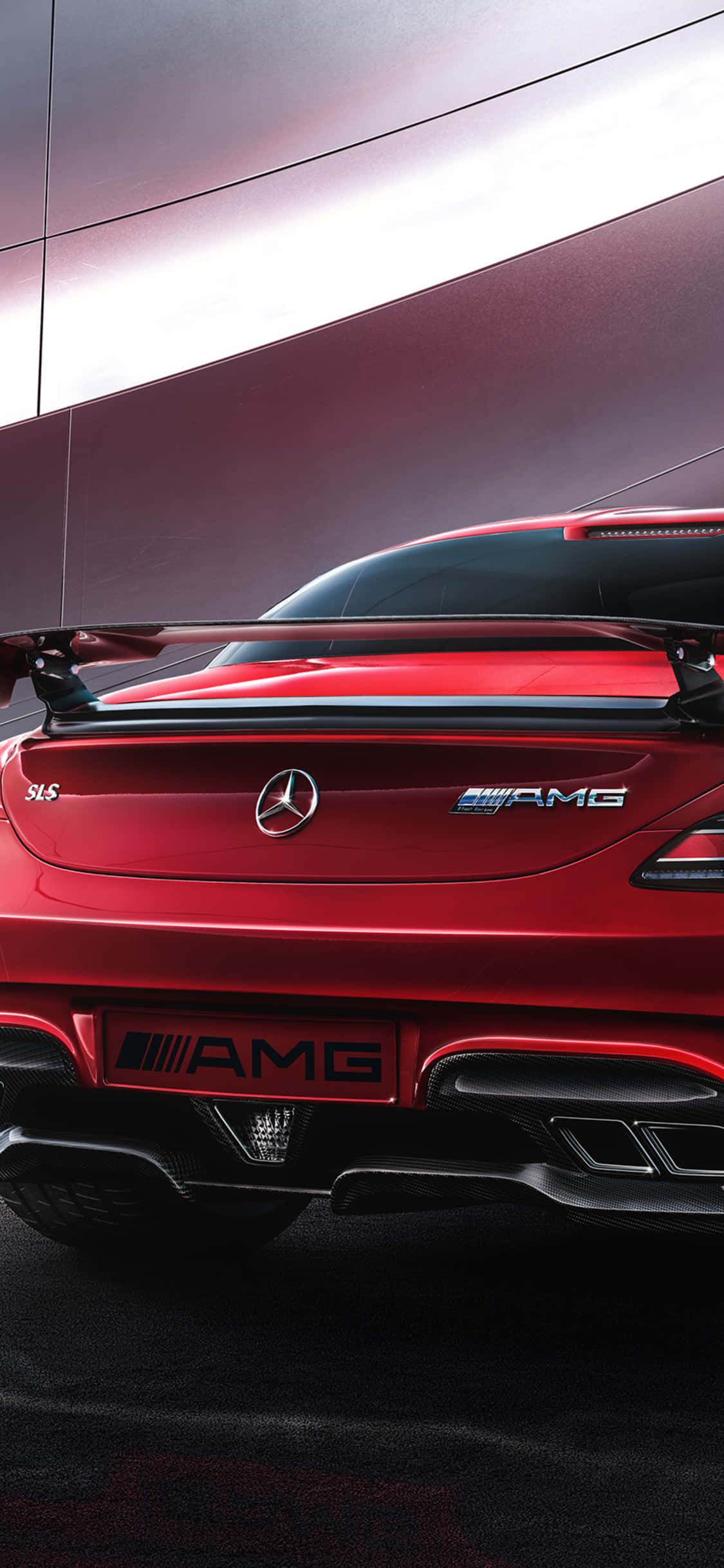 iPhone X Amg Gt-r 桌布 壁紙 — 一輛光亮的紅色Mercedes-AMG SLS跑車配備大型尾翼，在戲劇性燈光下以時尚現代建築外牆為背景展示。