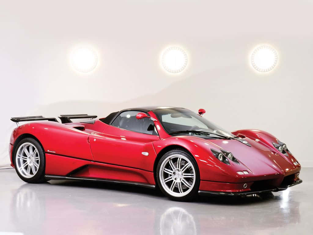 Pagani Zonda C12 Roadster 桌布 壁紙 — 一輛光亮的紅色帕加尼Zonda跑車在攝影棚燈光下，於反光地板上閃耀。