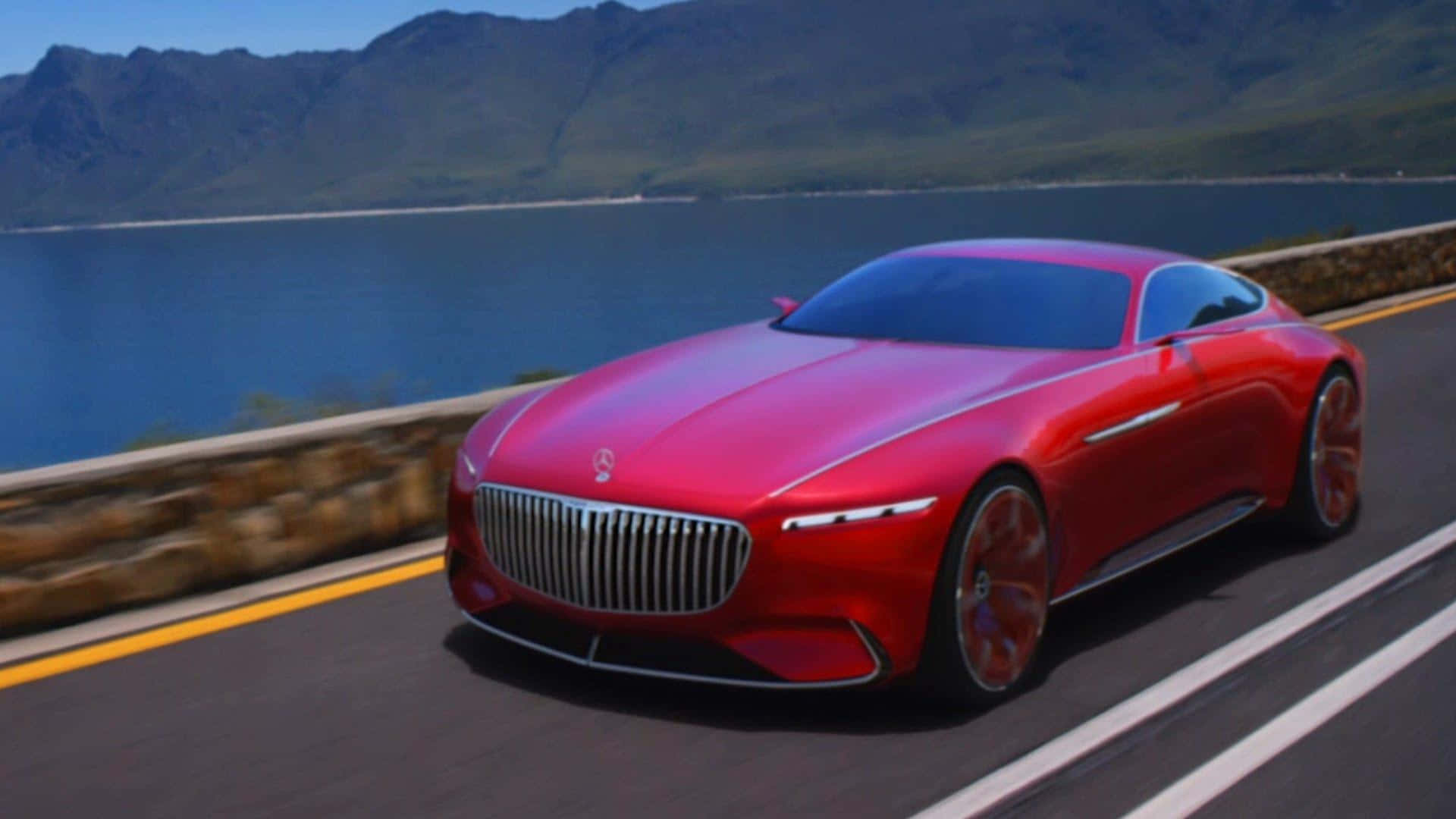 Maybach 桌布 壁紙 — 一輛光亮的紅色梅賽德斯概念車沿著海岸道路行駛，背景有山脈和藍色海水。