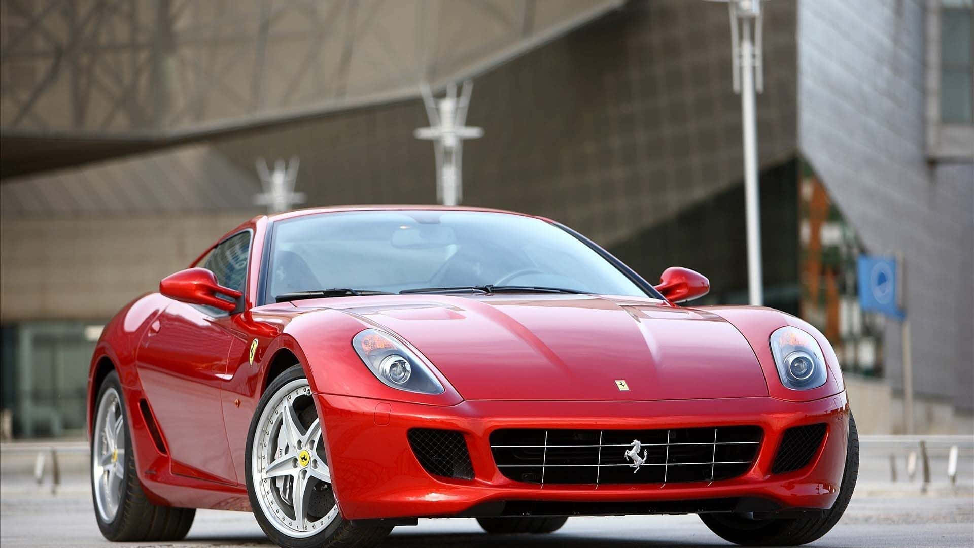 Ferrari 599 Gtb Fiorano 桌布 壁紙 — 一輛光亮的紅色法拉利跑車停放在現代混凝土建築前，建築線條銳利。