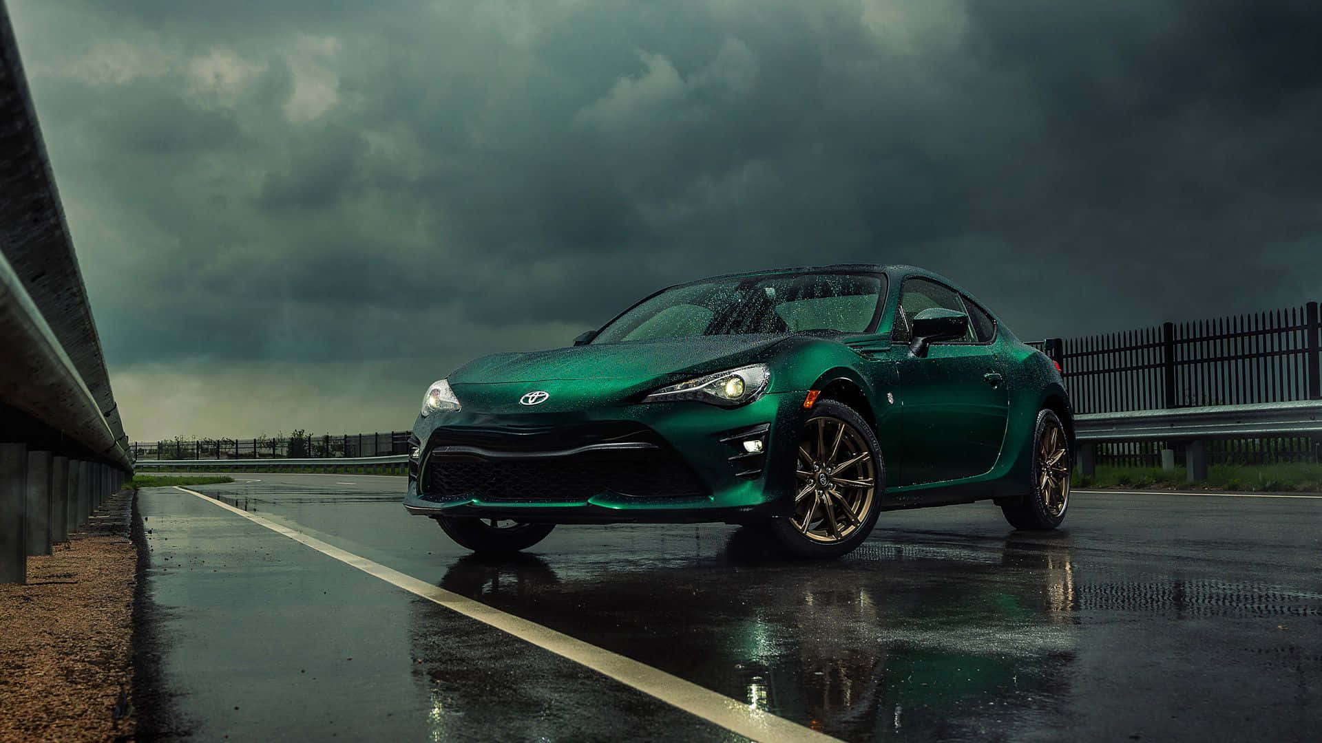 綠色跑車在潮濕道路上的風暴天空下帶倒影 — Toyota Supra Mk4 壁紙