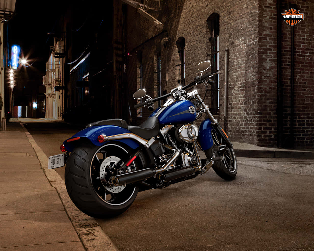 機車 桌布 壁紙 — 一輛光亮的藍色Harley-Davidson摩托車在夜間停放在燈光昏暗的磚砌小巷中，遠處有霓虹燈牌閃爍。