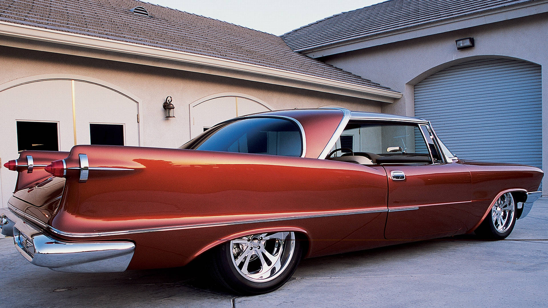 Chrysler 桌布 壁紙 — 一輛光亮的銅色經典汽車，帶有鍍鉻尾翼和定制輪圈，停在帶有拱形車庫門的米色房屋前。