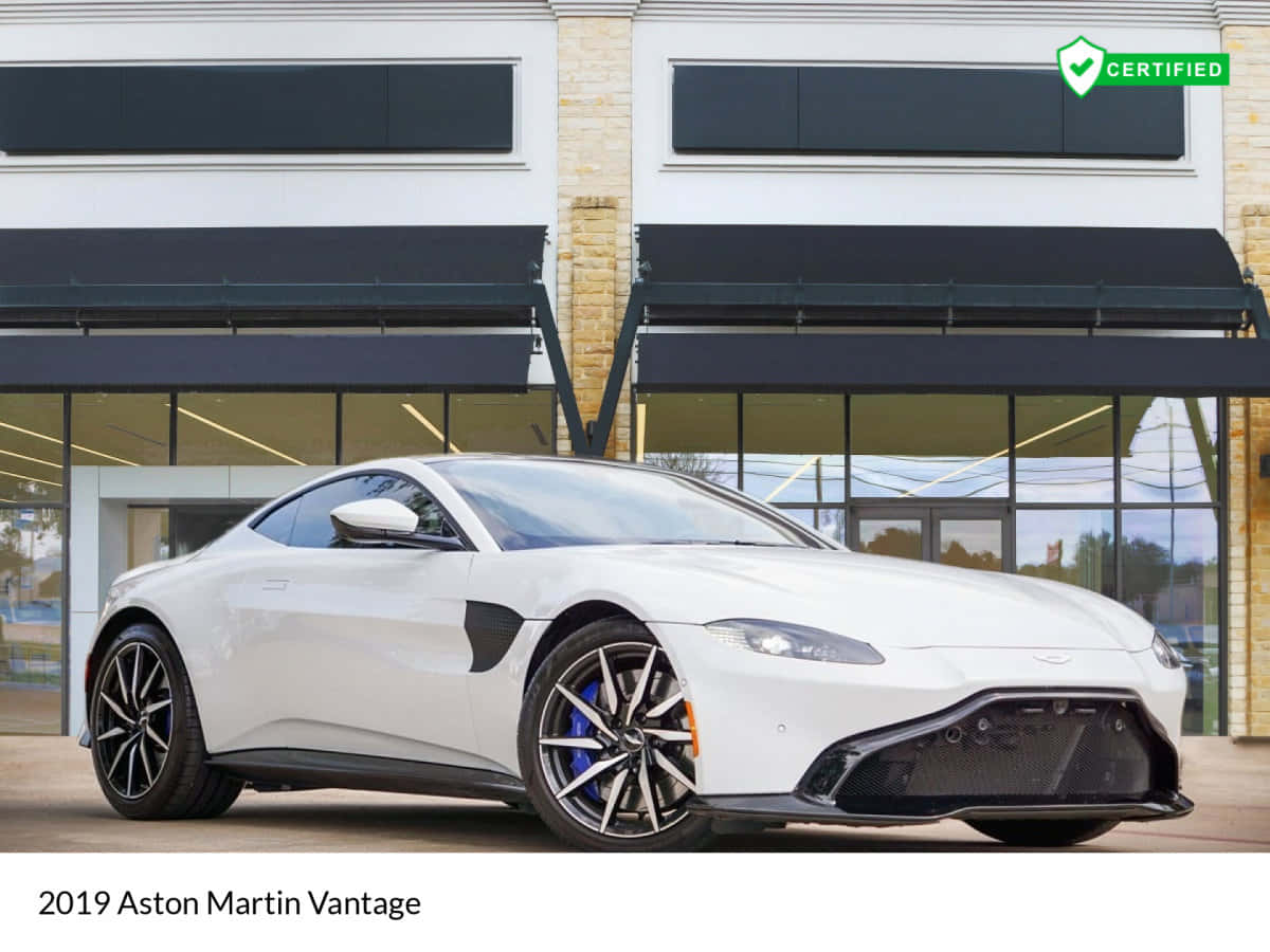 奧斯頓馬丁 桌布 壁紙 — 一輛光滑的白色2019年Aston Martin Vantage跑車停放在現代化經銷商前，帶有黑色遮陽篷。