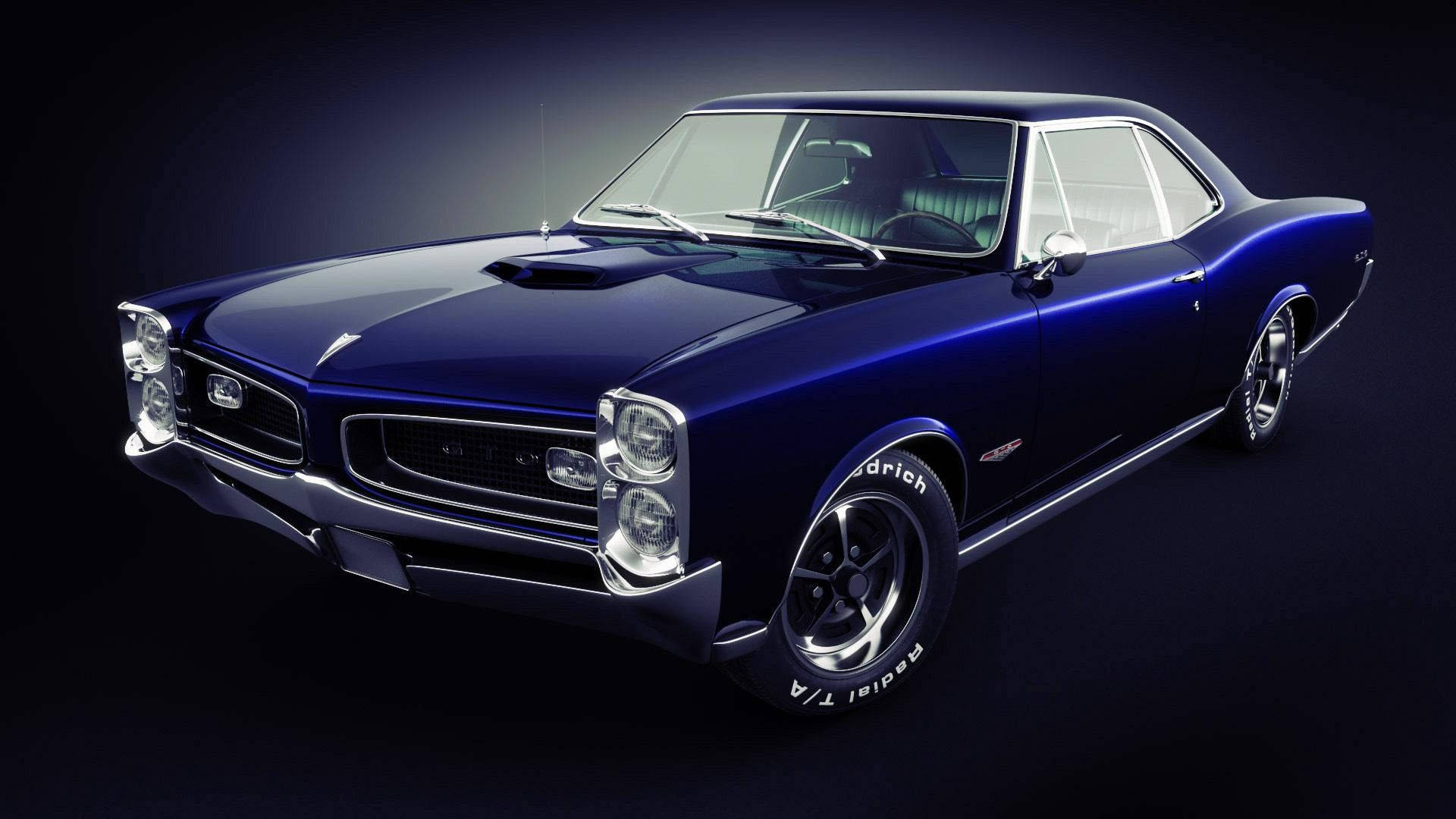 Pontiac 桌布 壁紙 — 一輛光澤深藍色經典肌肉車，帶有鍍鉻裝飾和白色輪胎，在暗色背景的攝影棚燈光下閃耀。
