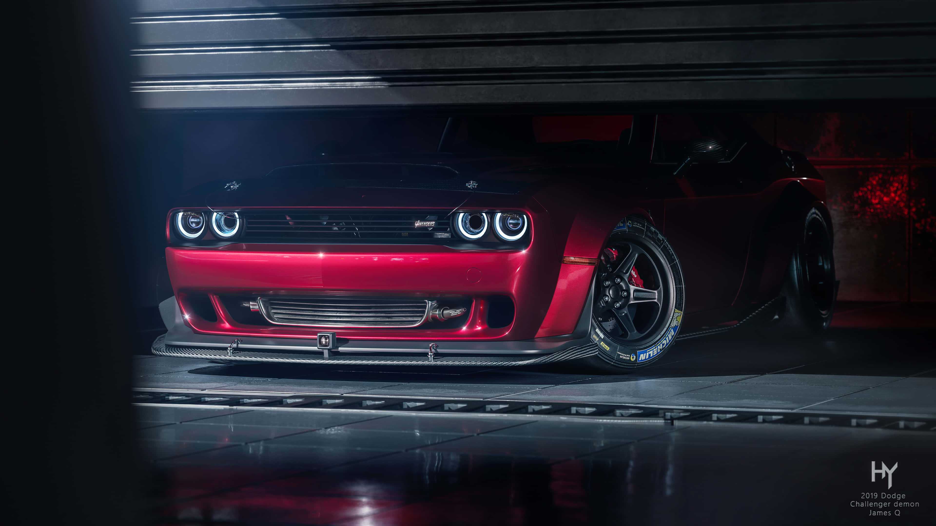 桌布 壁紙 — 一輛光澤的紅色 Dodge Challenger SRT Hellcat 在戲劇性的車庫燈光下閃耀，帶有發光的頭燈和碳纖維飾件。