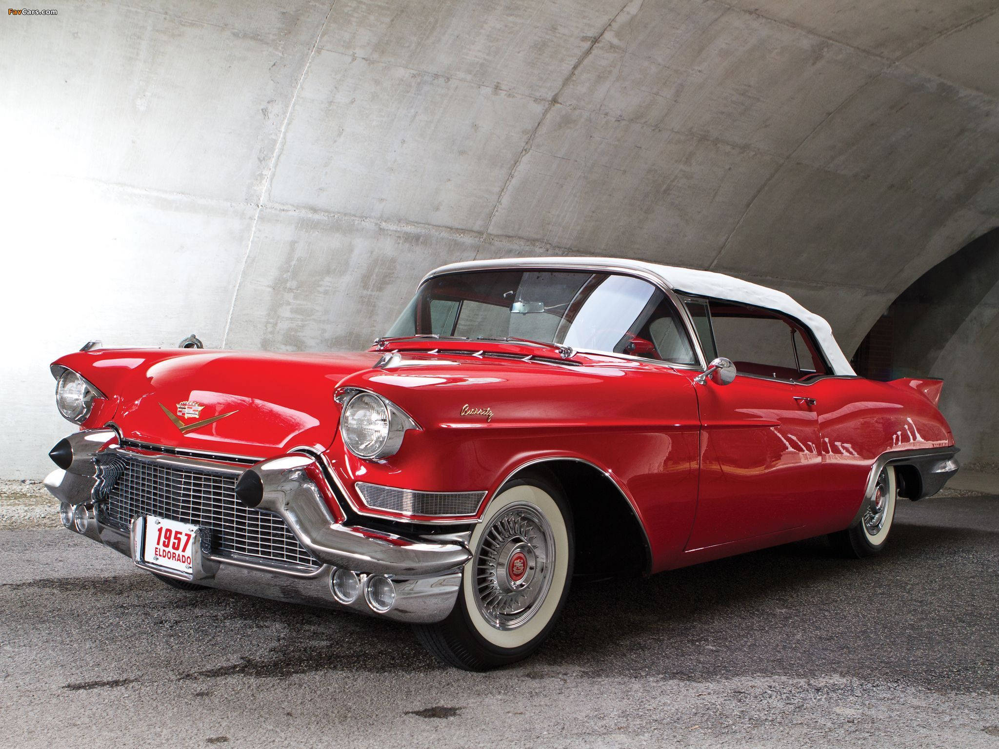 Cadillac 桌布 壁紙 — 一輛光澤的紅色1957年凱迪拉克敞篷車，白色車頂和鍍鉻細節，停在混凝土隧道下。