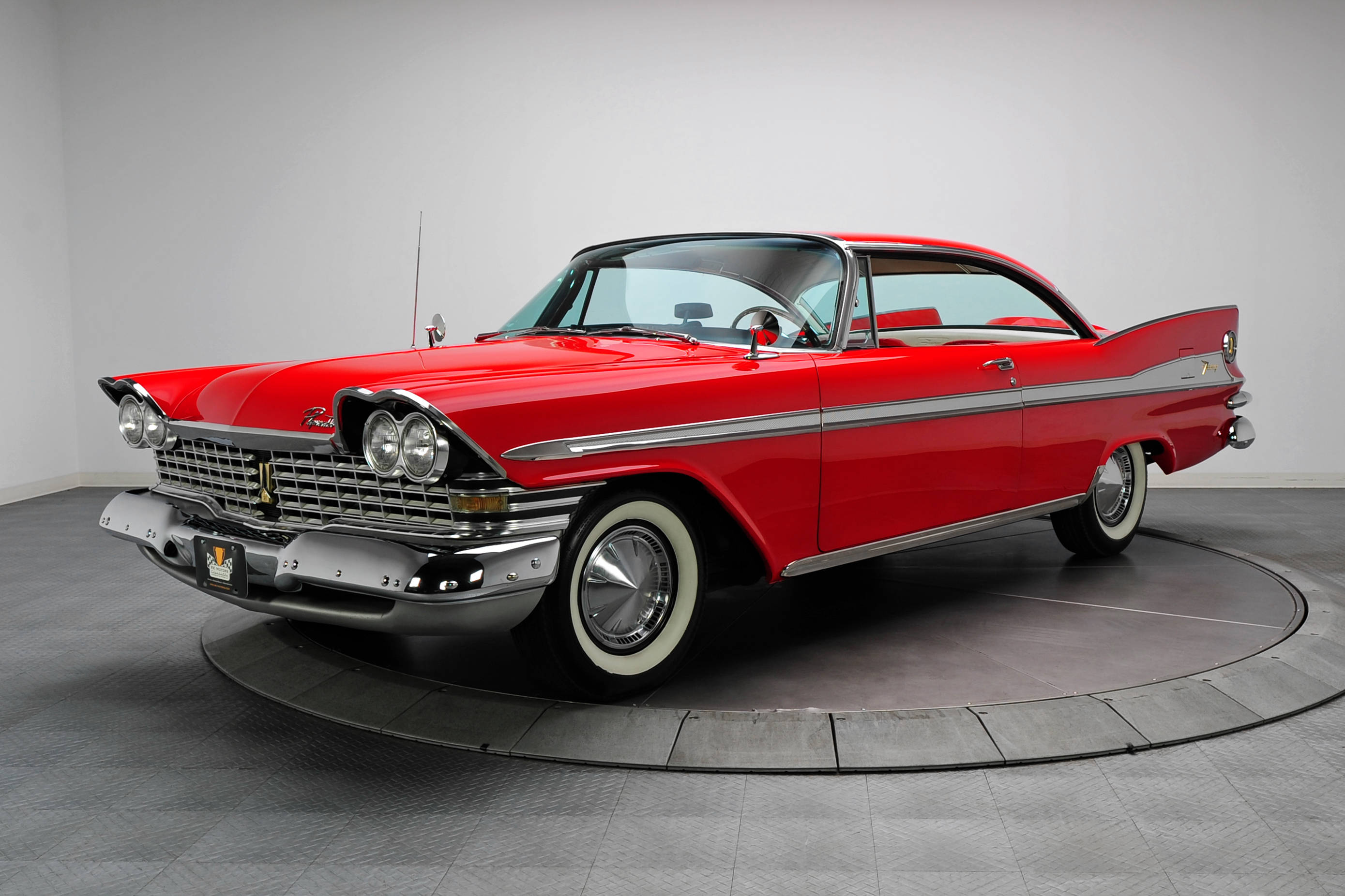 經典汽車 桌布 壁紙 — 一輛光澤的紅色1959年雪佛蘭Bel Air經典車，帶有鍍鉻裝飾和白牆輪胎，放置在極簡工作室的旋轉展示台上。