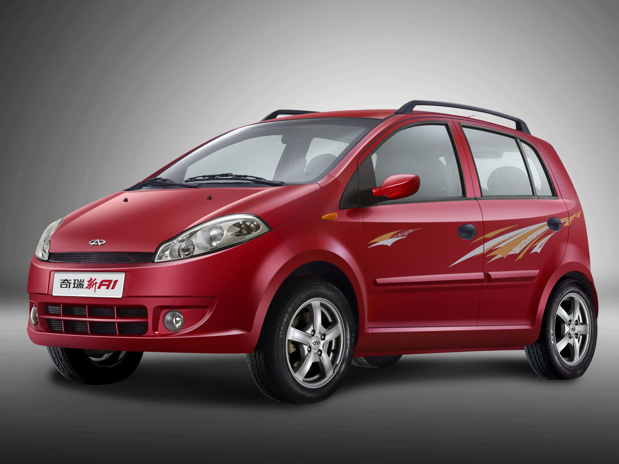 Chery 桌布 壁紙 — 一輛光澤的紅色Chery A1緊湊型汽車，帶有金色側面貼花和車頂行李架，在漸變灰色背景下的工作室拍攝中展示。