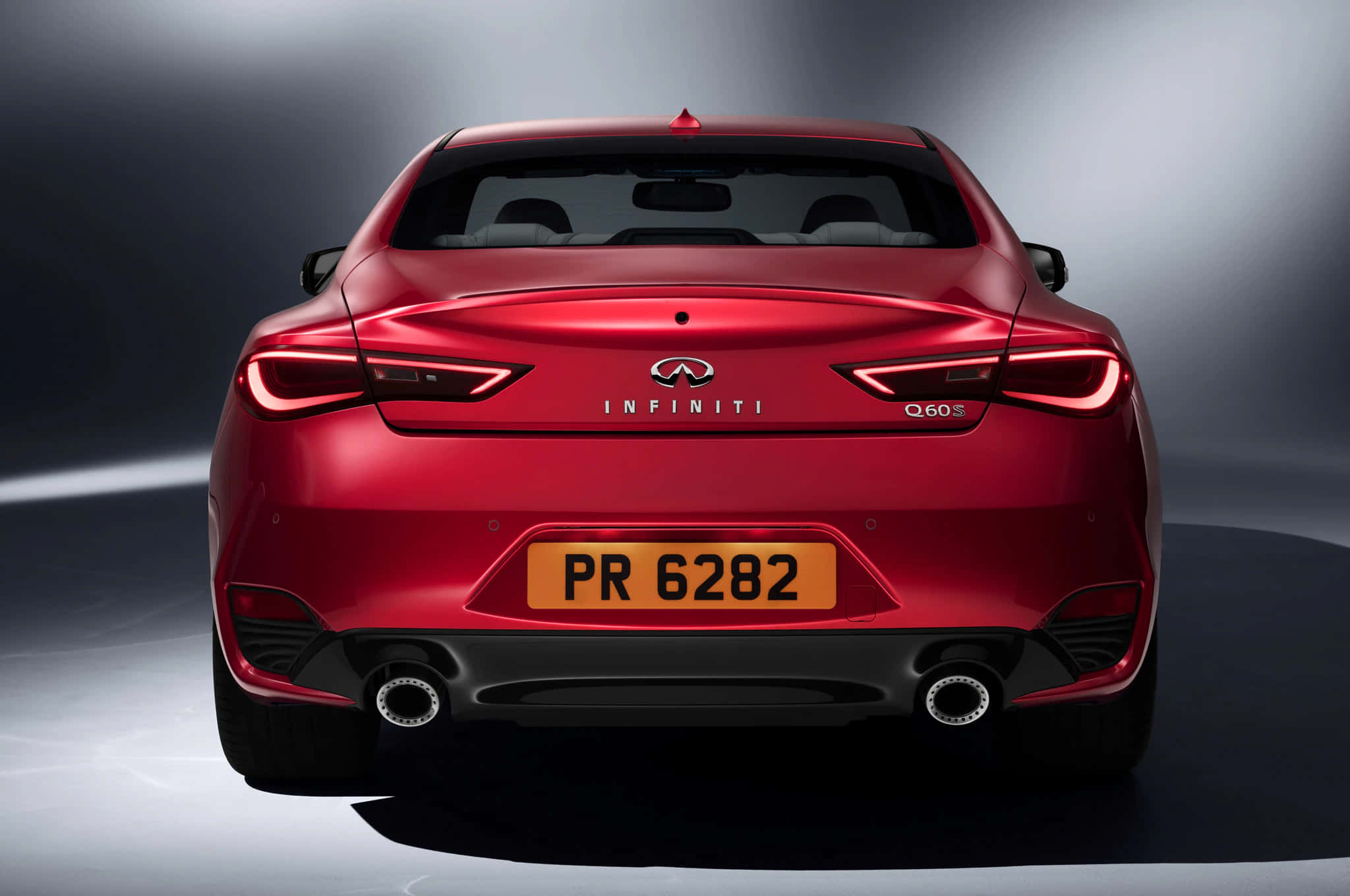 Infiniti Q60 桌布 壁紙 — 一輛光澤的紅色Infiniti Q60跑車，在攝影棚燈光下從後方觀看，背景為灰色漸變。