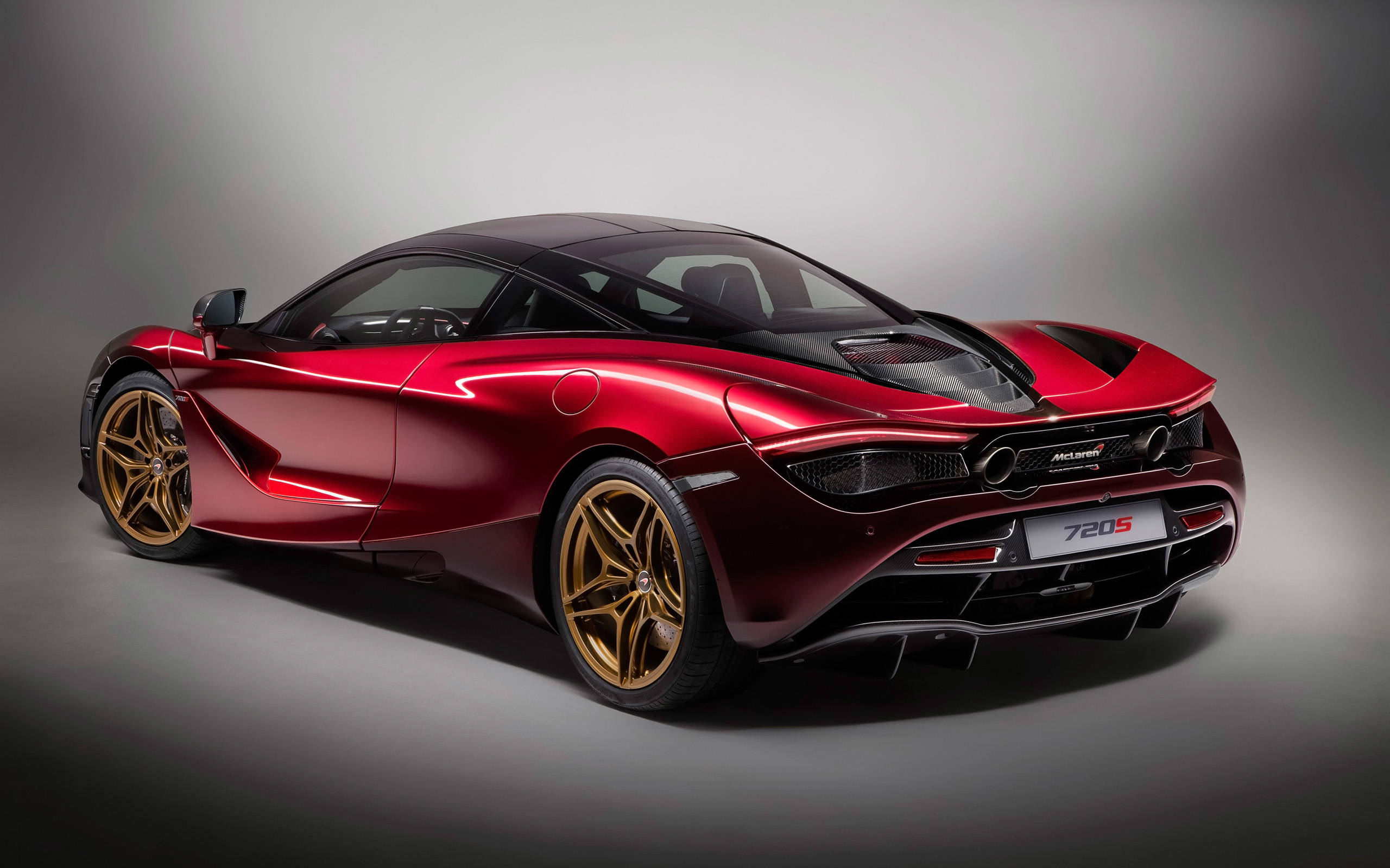mclaren 720s 4K 桌布 壁紙 — 一輛光澤的紅色McLaren 720S跑車配金色輪圈，在戲劇性照明的攝影棚中展示。
