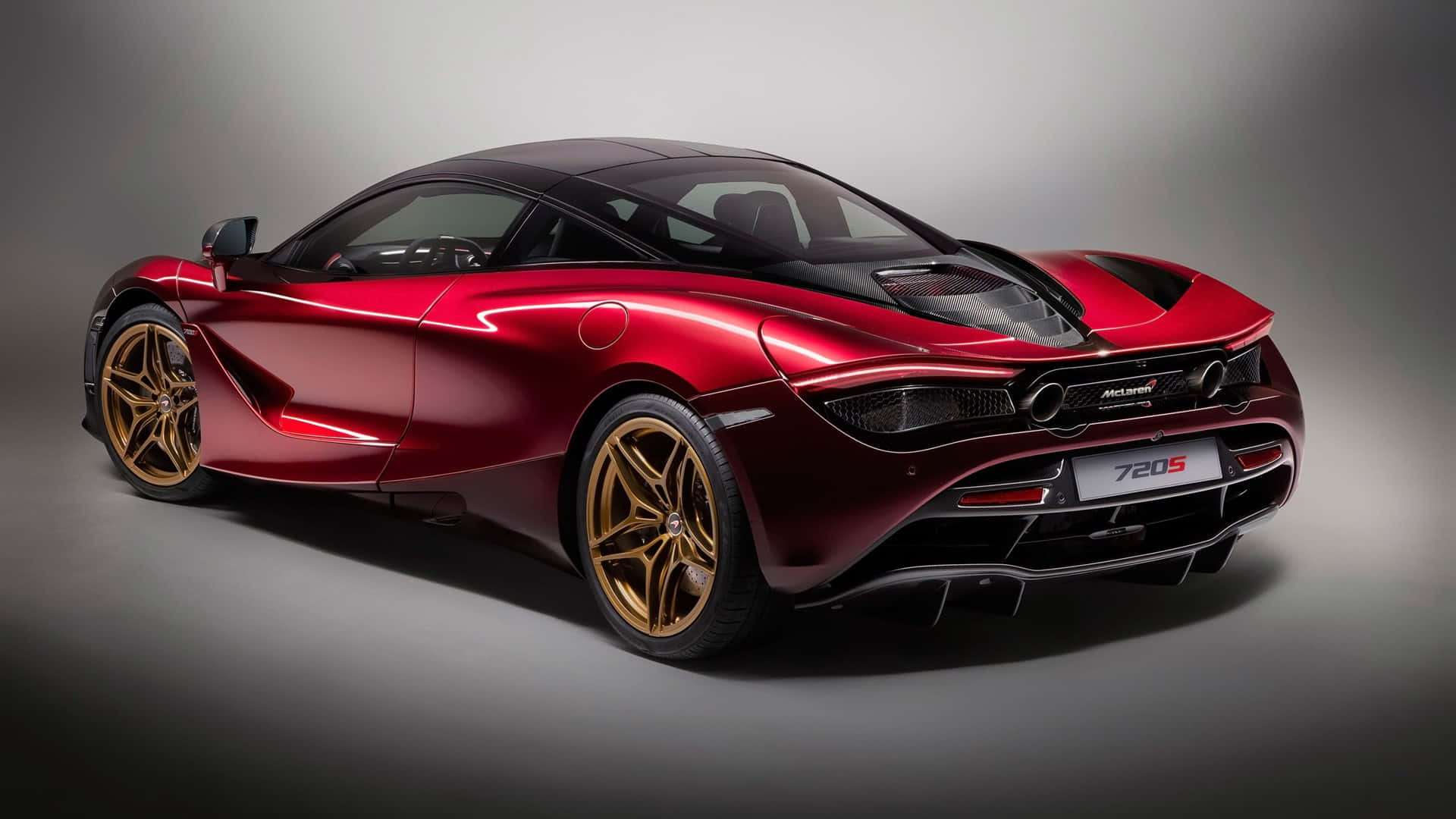 紅色動圖 桌布 壁紙 — 一輛光澤的紅色McLaren 720S跑車配金色輪圈，在工作室中展示，燈光效果戲劇化。