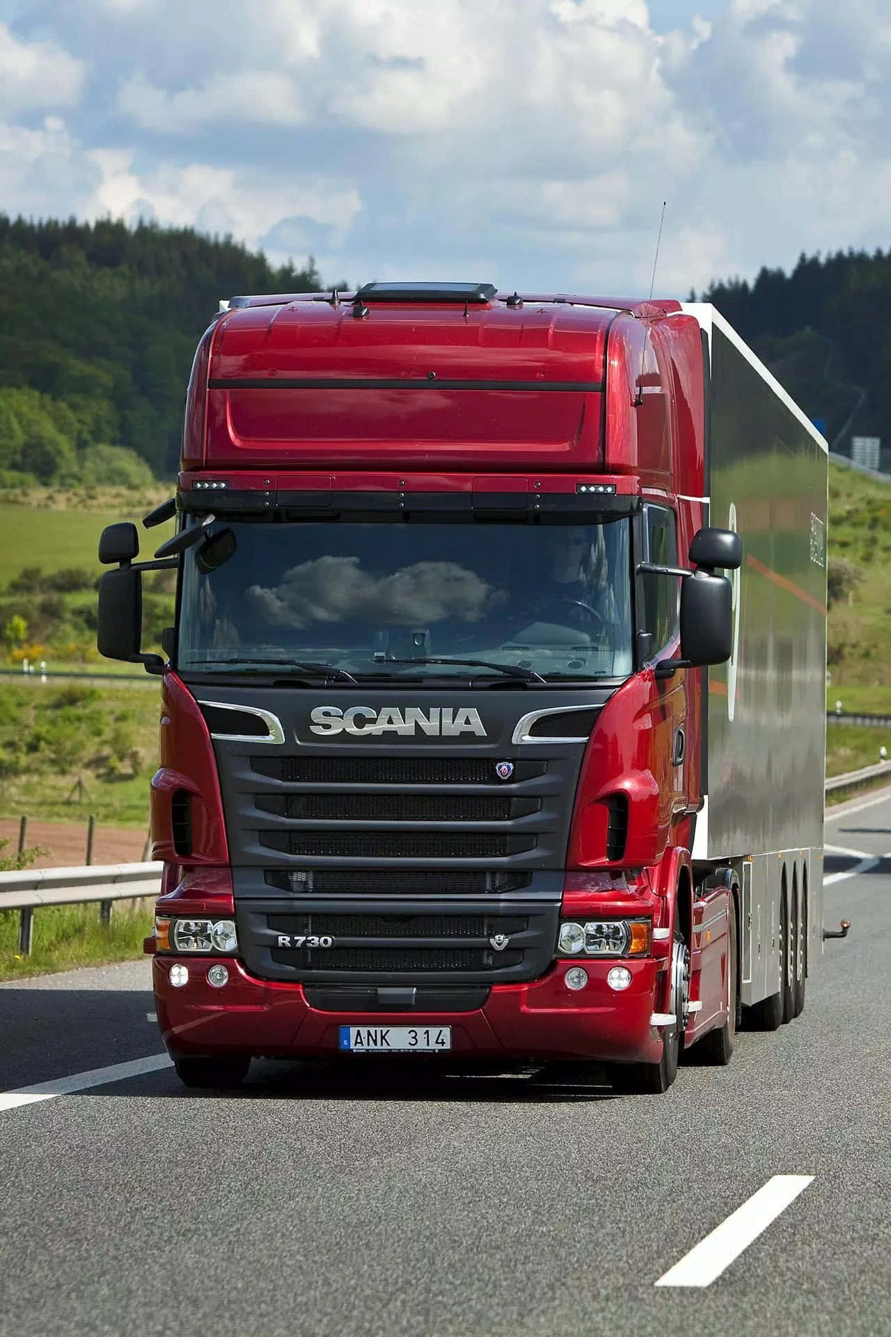 Truck 桌布 壁紙 — 一輛光澤的紅色Scania R730卡車拖著銀色拖車，在部分多雲的天空下，行駛在兩旁綠丘環繞的陽光高速公路。
