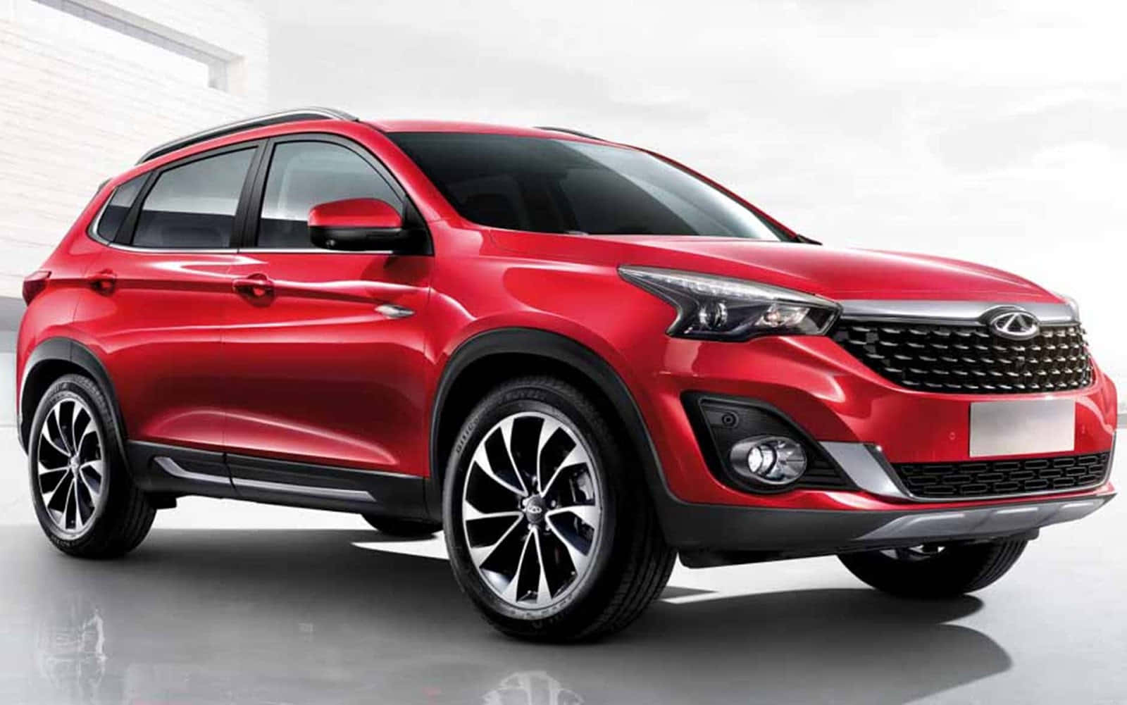 Chery 桌布 壁紙 — 一輛光澤的紅色SUV，配備時尚合金輪圈和現代頭燈，在極簡工作室背景前蓄勢待發。
