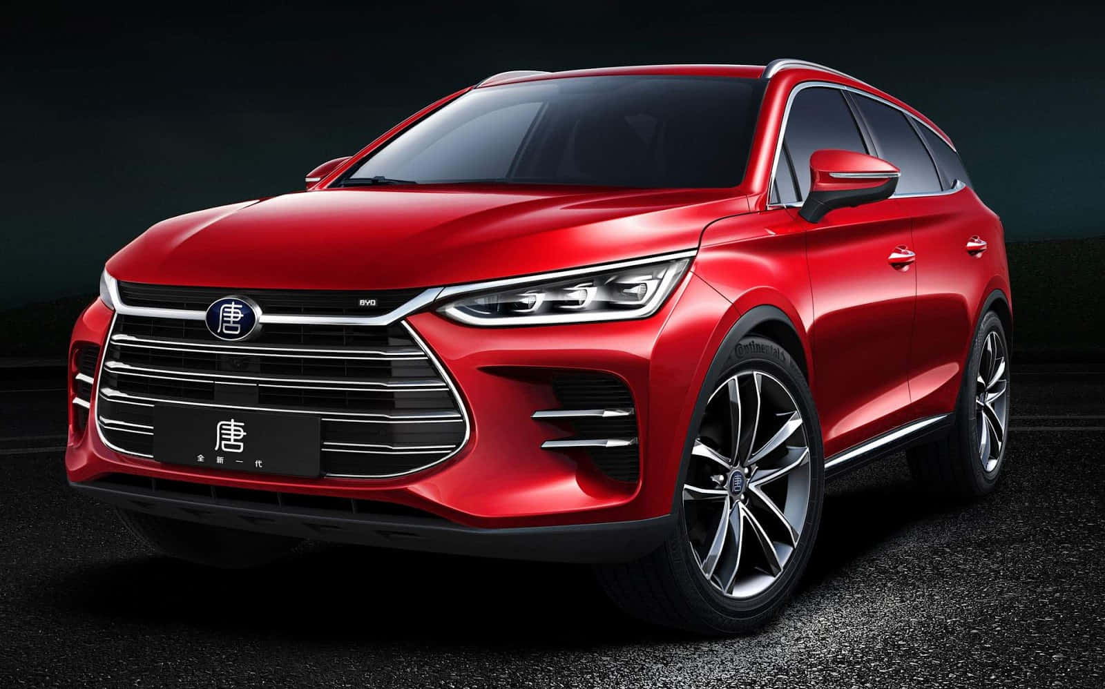 Byd 桌布 壁紙 — 一輛光澤的紅色SUV，配備時尚的頭燈和鍍鉻飾條，在戲劇性的工作室燈光下，停在深色瀝青路面上。
