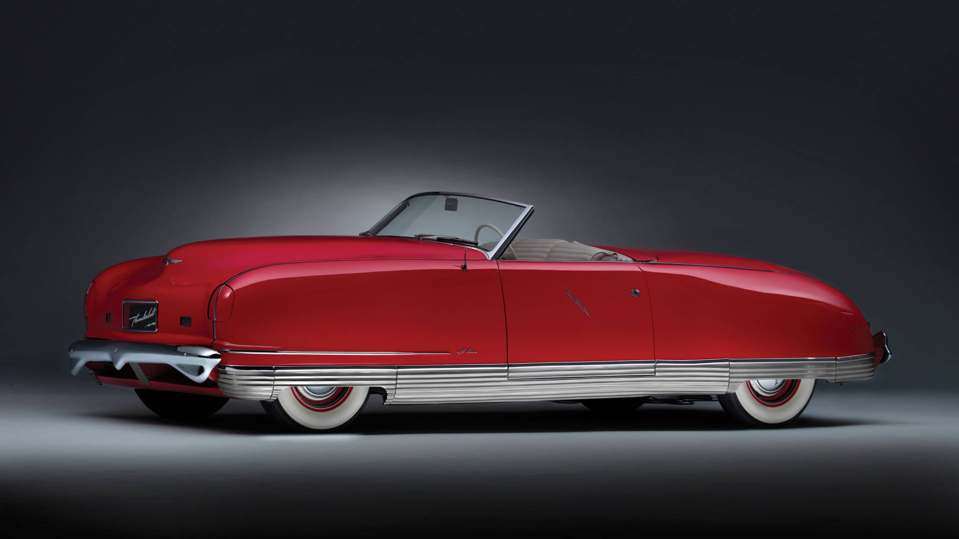 Chrysler 桌布 壁紙 — 一輛光澤的紅色復古敞篷車，帶有鍍鉻飾條和白邊輪胎，在暗色漸變背景下的攝影棚燈光中閃耀。