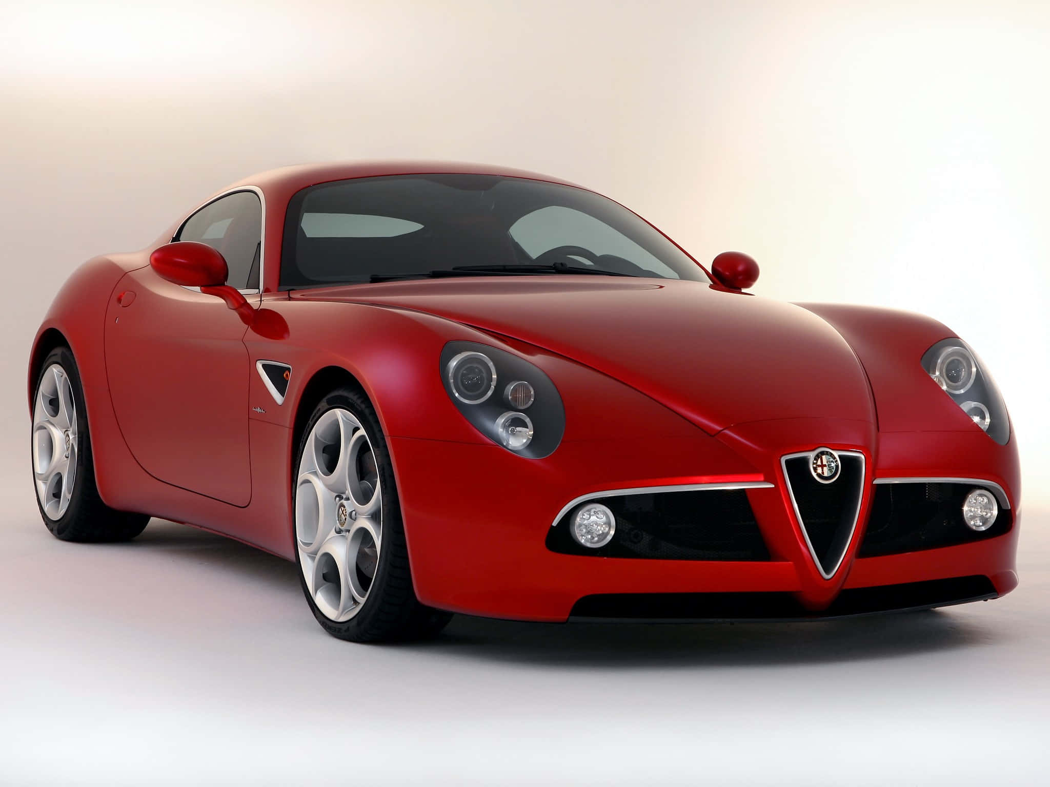 Alfa Romeo 8c Competizione 桌布 壁紙 — 一輛光澤的紅色愛快羅密歐跑車配銀色輪圈，在明亮的攝影棚中拍攝。