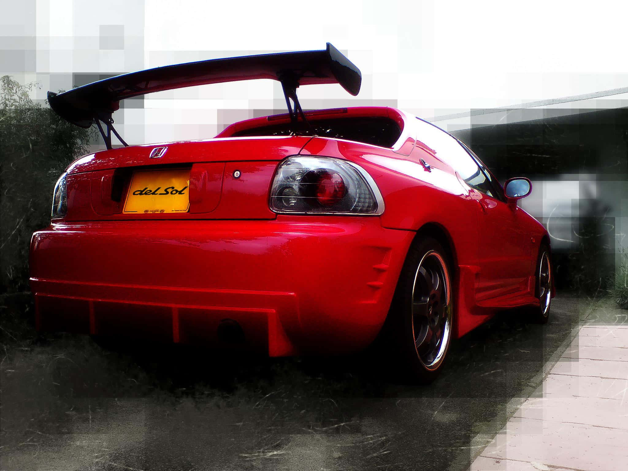 Honda Civic Del Sol 桌布 壁紙 — 一輛光澤的紅色本田 Del Sol 跑車，帶有大型後擾流板，停放在潮濕的路面上，天空多雲。