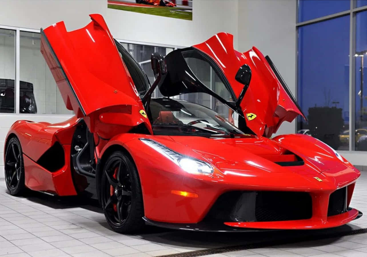 法拉利 桌布 壁紙 — 一輛光澤的紅色法拉利LaFerrari，剪刀門打開，停在現代化的展廳中，地板鋪有瓷磚，有大窗戶。