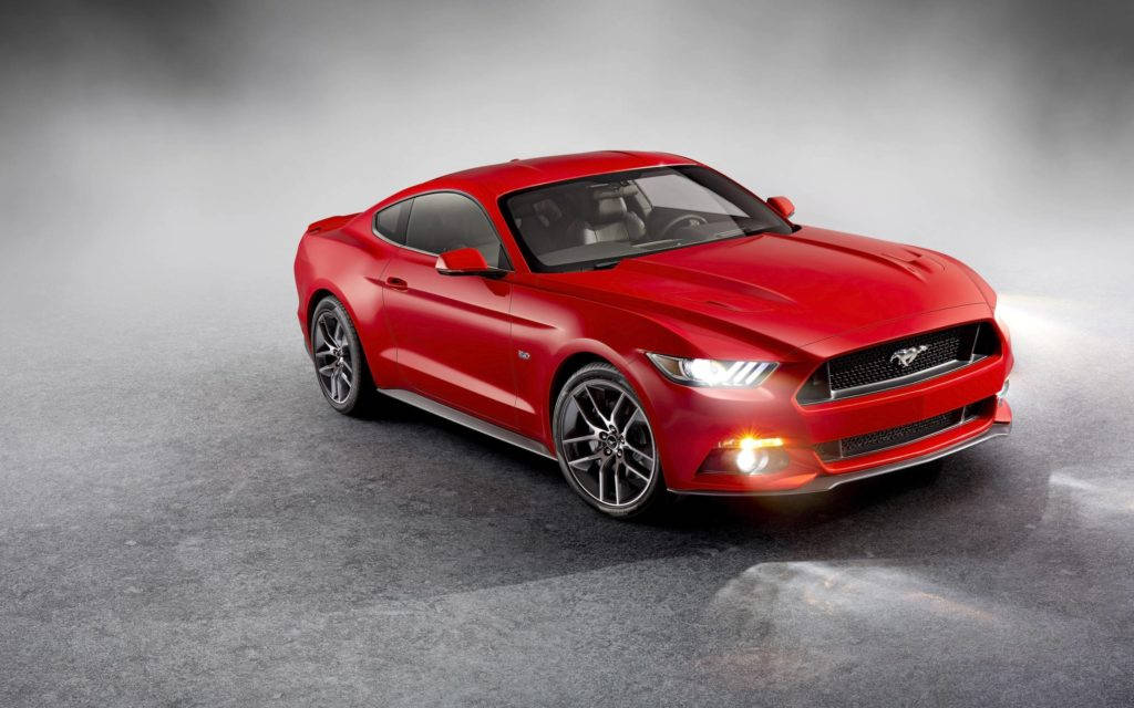 mustang HD 桌布 壁紙 — 一輛光澤的紅色福特野馬跑車在煙霧灰色背景的攝影棚燈光下閃閃發光。