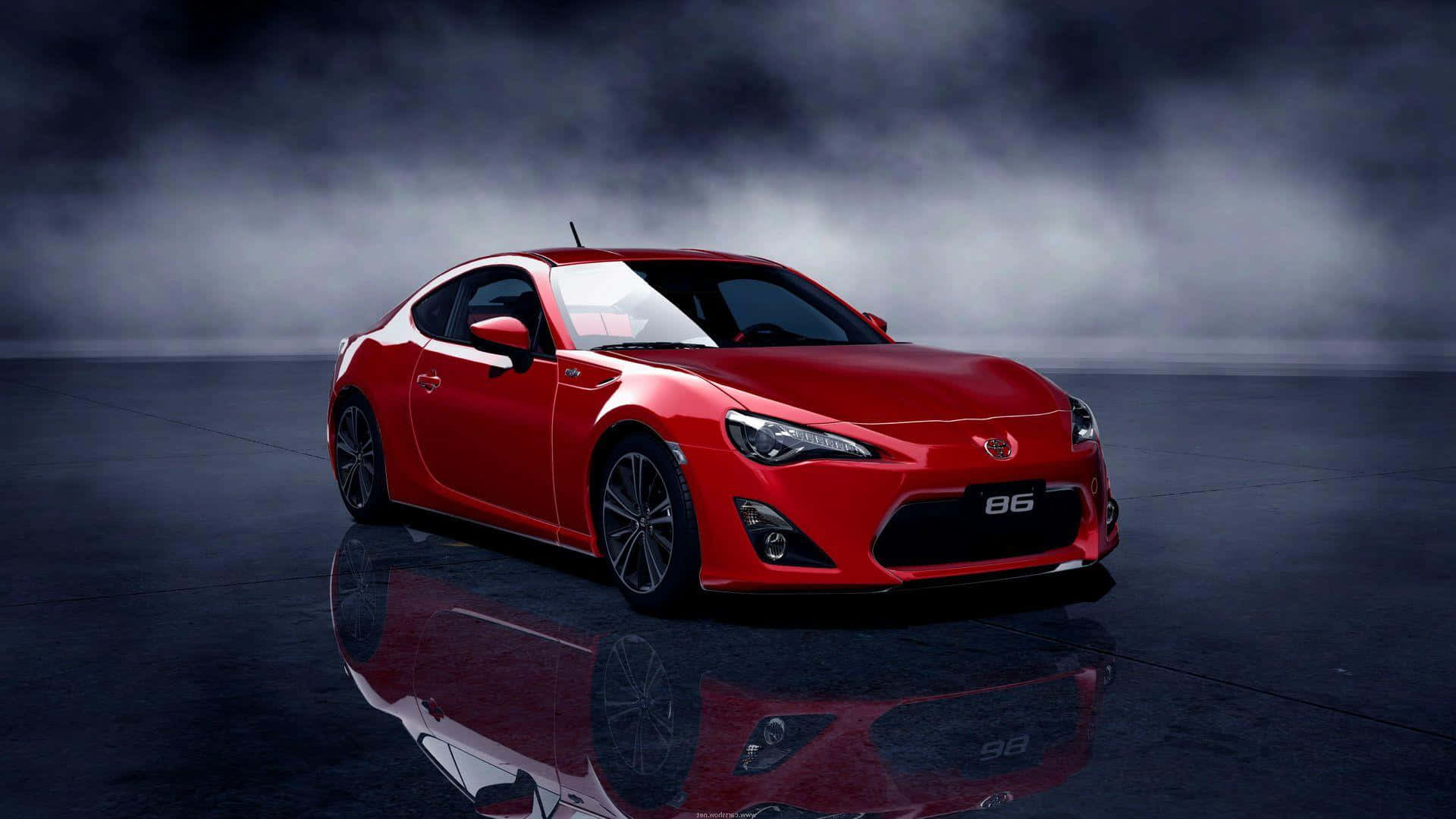 Toyota 桌布 壁紙 — 一輛光澤的紅色豐田86跑車在戲劇性的工作室燈光下閃耀，背景迷濛，地板反射。