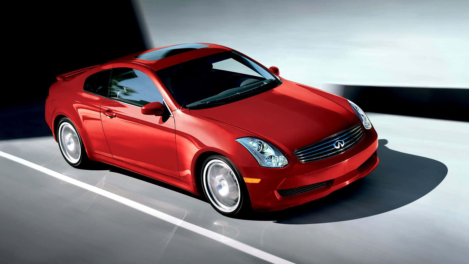 Infiniti G35 桌布 壁紙 — 一輛光澤的紅色跑車，擁有流暢的曲線和鍍鉻裝飾，在極簡工作室背景下戲劇性地打光。