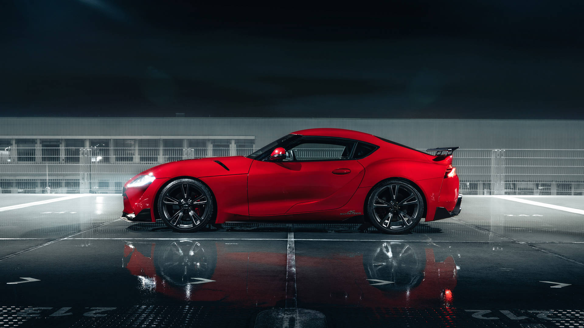 紅色跑車停在濕滑路面上，在夜燈下反射倒影。 — Toyota Supra Mk4 壁紙