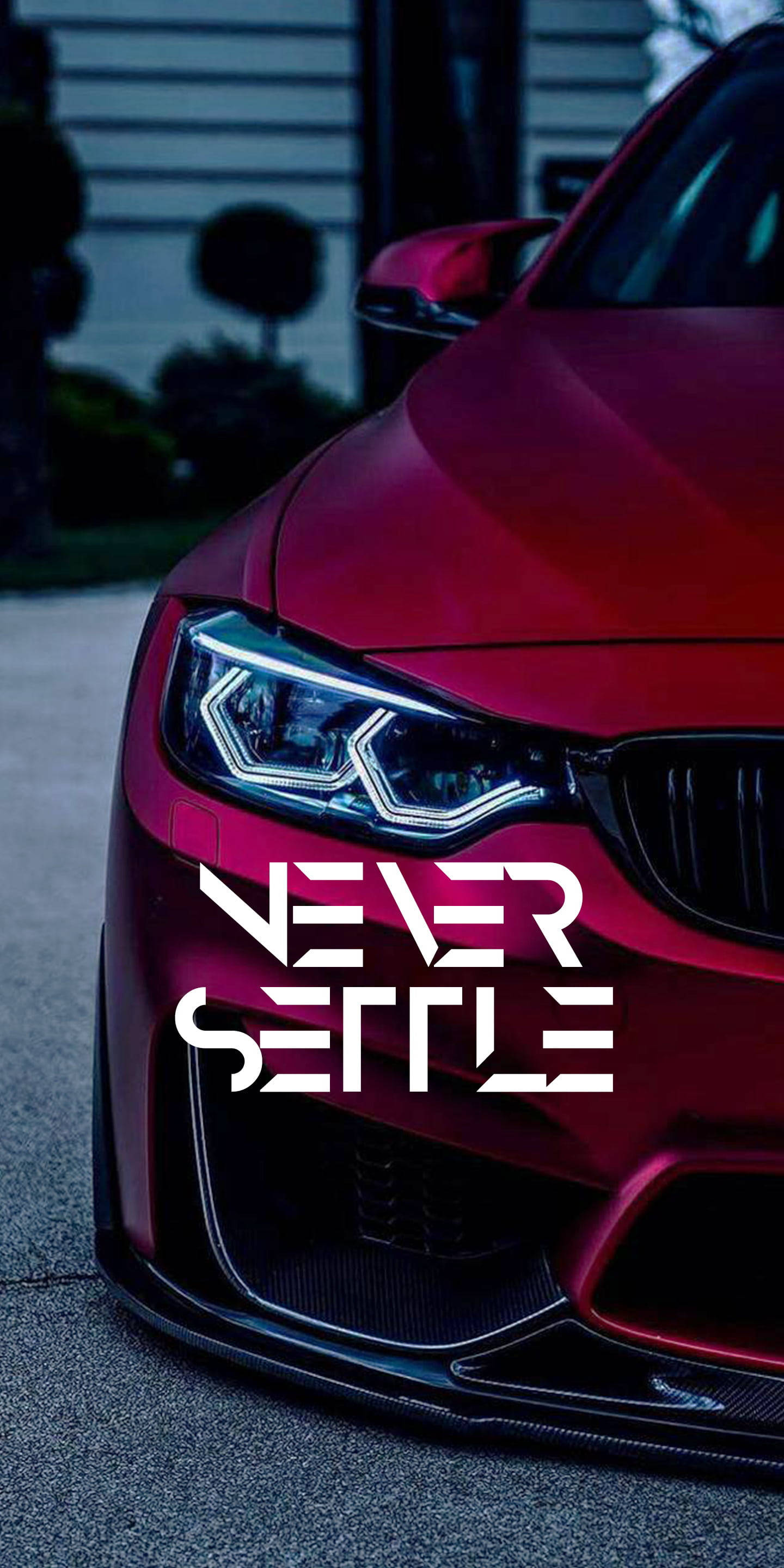 語錄 桌布 壁紙 — 一輛光澤的紅色跑車近距離特寫，帶有'NEVER SETTLE'文字疊加，在黃昏時停放在車道上。
