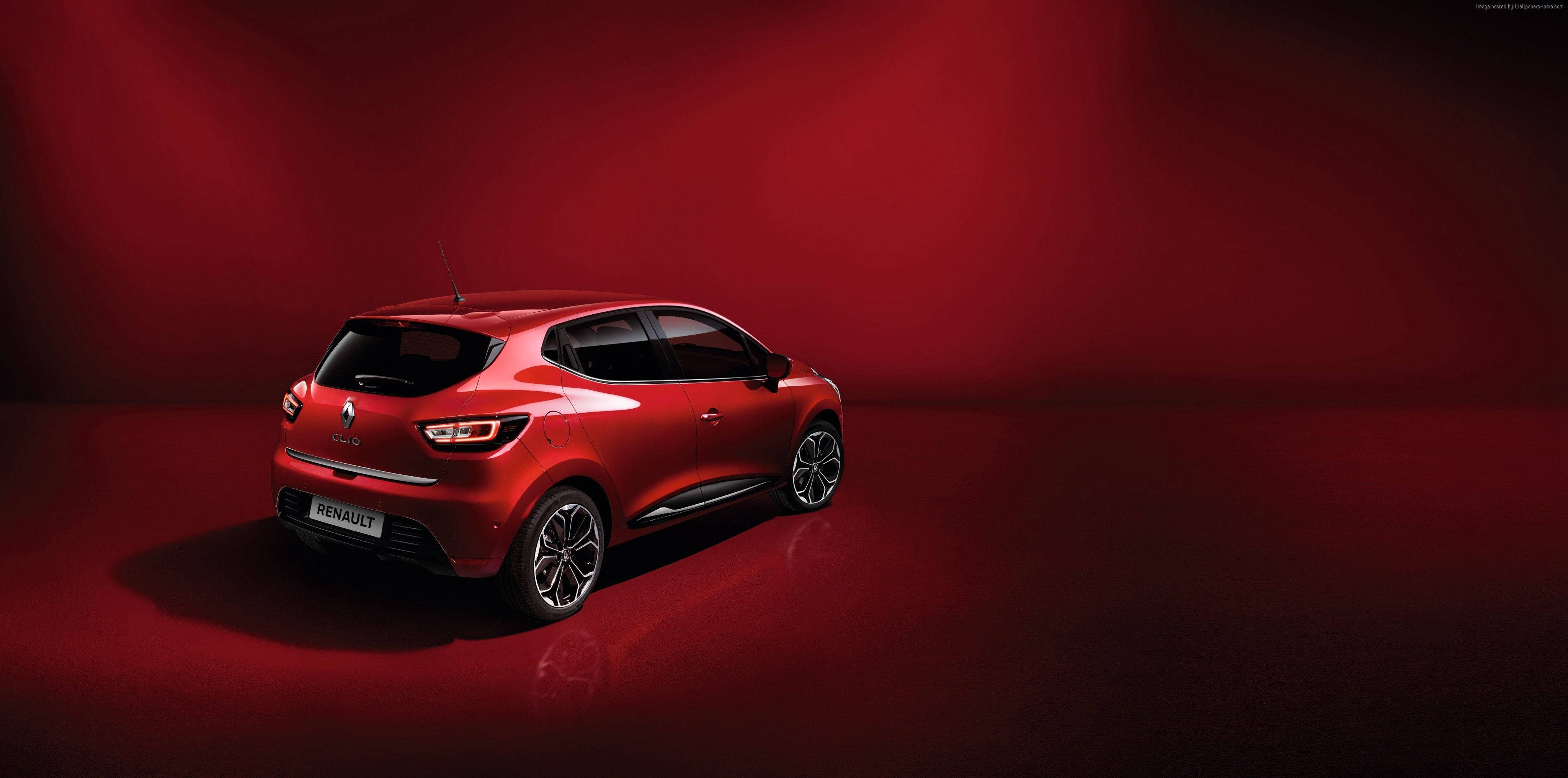Renault 桌布 壁紙 — 一輛光澤的紅色雷諾Clio掀背車在深紅色燈光和反射地板的攝影棚中展示。