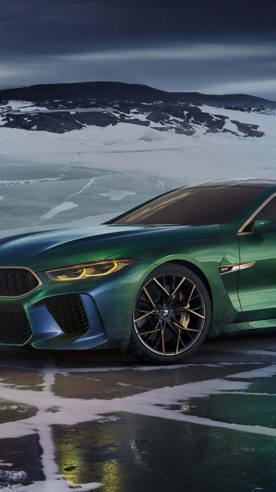 Bmw M8 4K 桌布 壁紙 — 一輛光澤的綠色BMW M8 Coupe在雪覆蓋的冰凍湖面上閃耀，背景是陰鬱的暮色天空。