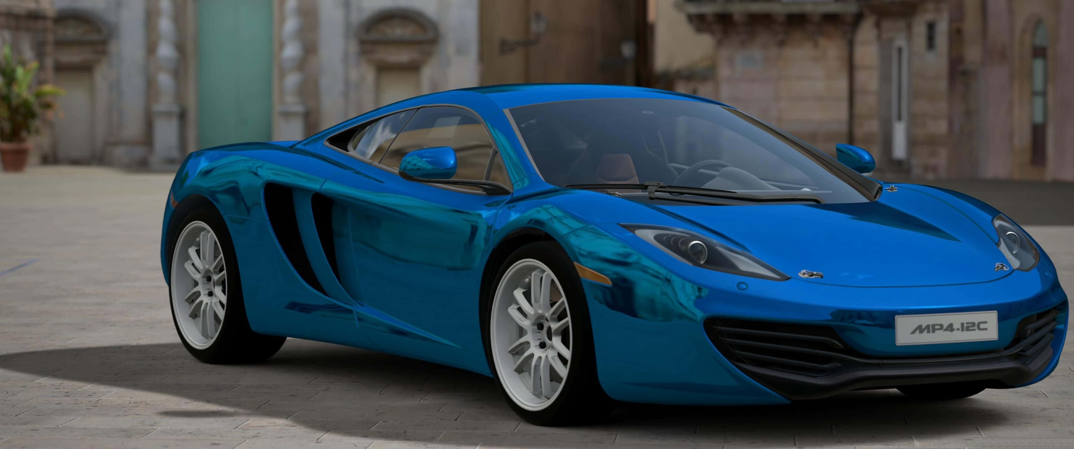 Blue Car 桌布 壁紙 — 一輛光澤的藍色McLaren MP4-12C跑車在日光下閃耀，背景是石鋪廣場和柔焦的歷史建築。