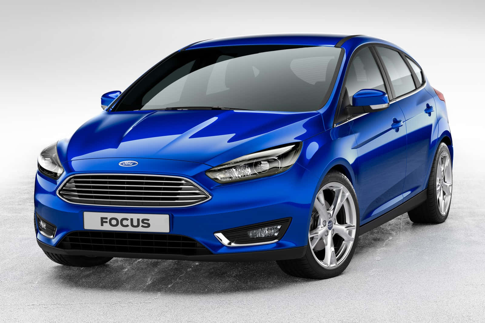 Ford Focus 桌布 壁紙 — 一輛光澤的藍色福特福克斯掀背車在攝影棚燈光下，在灰色中性地板上閃閃發光。