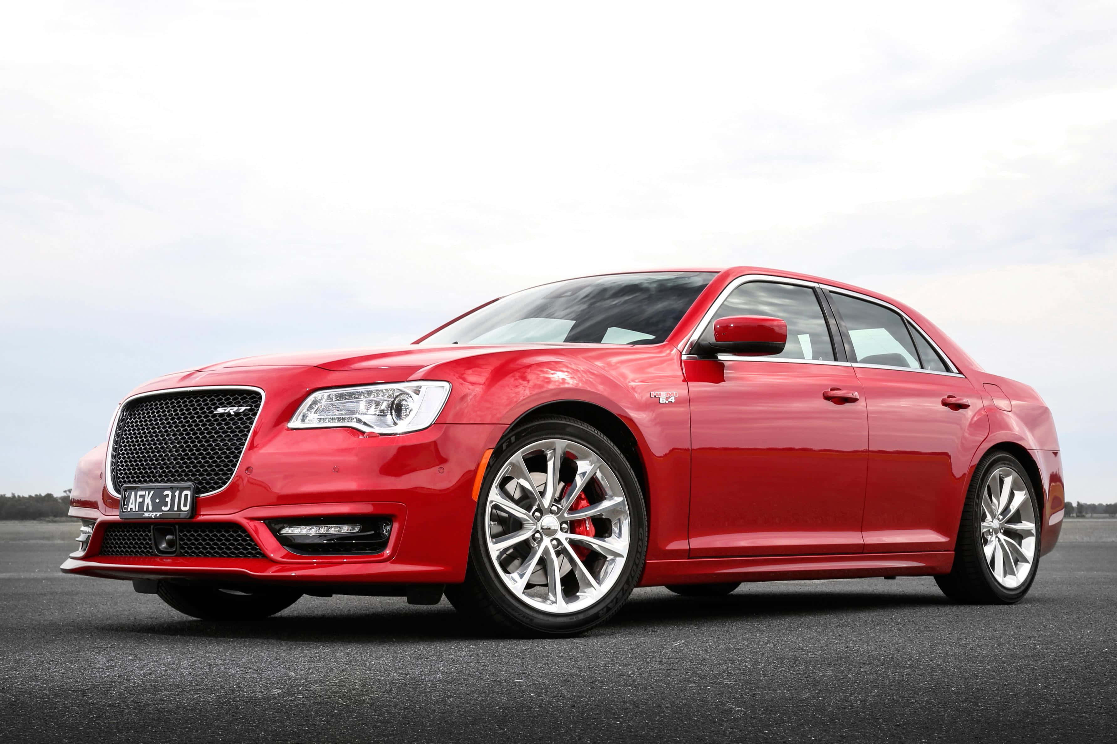 Chrysler 桌布 壁紙 — 一輛光澤紅色Chrysler 300 SRT轎車，配備銀色輪圈和紅色制動卡鉗，停放在陰天下的瀝青路面上。