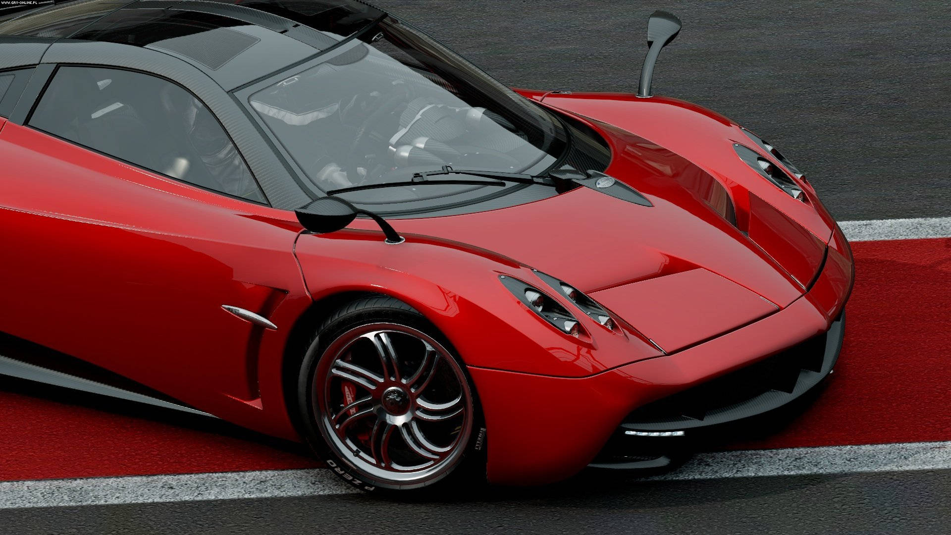 cars 桌布 壁紙 — 一輛光澤紅色Pagani Huayra跑車停放在設有白色和紅色路緣石的賽道上。