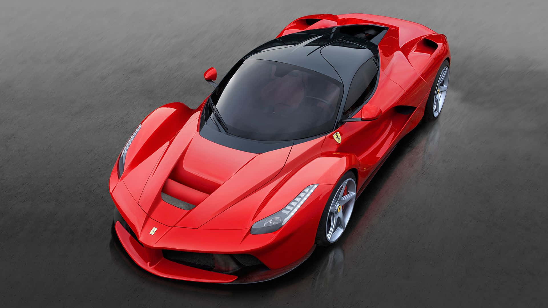 Ferrari Laferrari 桌布 壁紙 — 一輛光澤紅色法拉利LaFerrari超級跑車，配備黑色車頂和銀色輪圈，在工作室燈光下停在潮濕的深色路面上。
