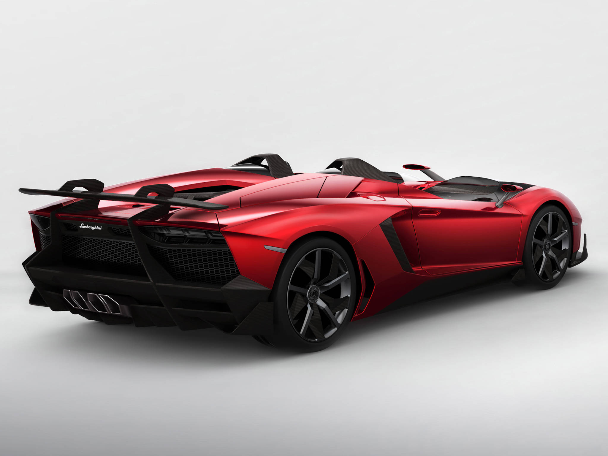 4K 藍寶堅尼 桌布 壁紙 — 一輛光澤紅色藍寶堅尼Aventador Roadster，帶有黑色飾件和大型尾翼，在工作室燈光下展示。